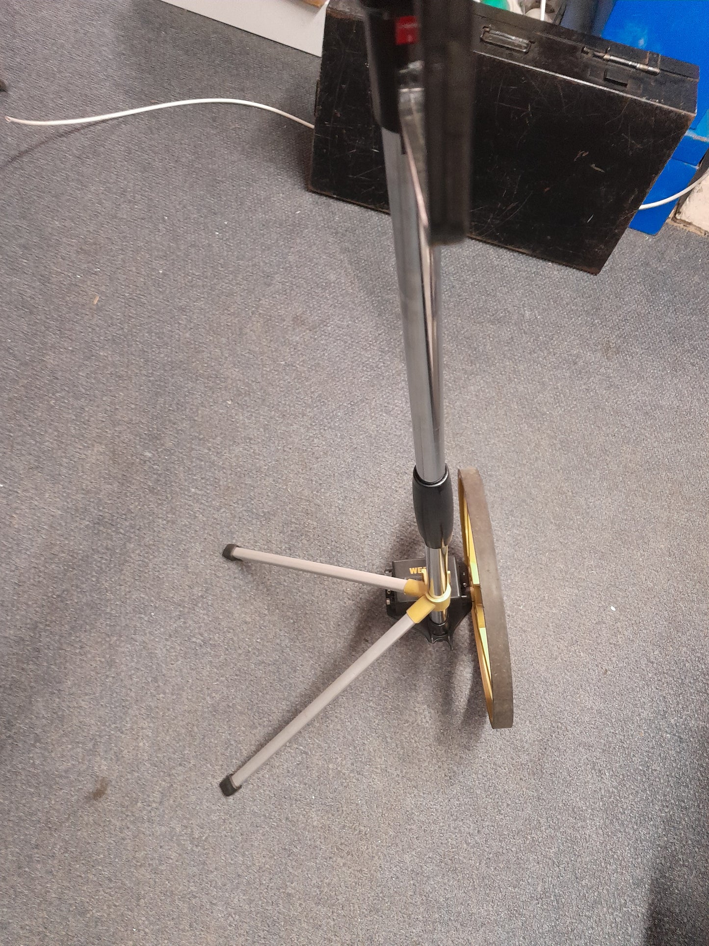 Close-up of Webco Distance Measuring Wheel with gold-colored wheel and black rim, mounted on a handle with tripod stand for stability, available at Die Skatkis.