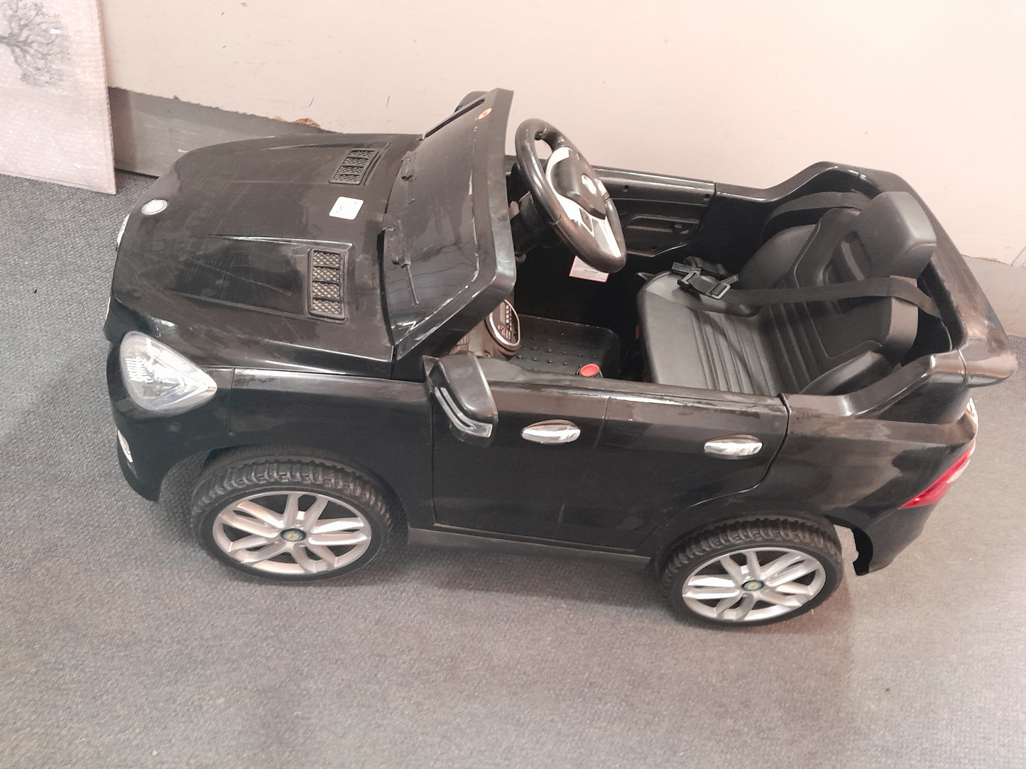 Die Skatkis secondhand store: Black Mercedes Benz kiddies car, battery-powered, showing realistic details like wheels and seatbelt.