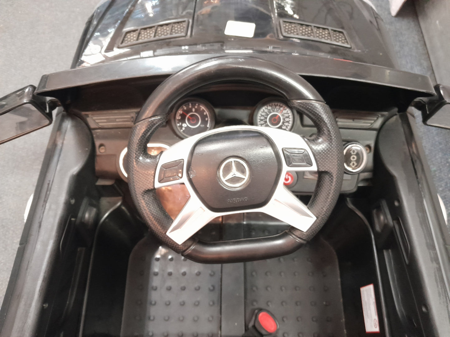 Die Skatkis secondhand store: Detailed interior of a Mercedes-Benz kiddies car, featuring realistic steering wheel and gauges.