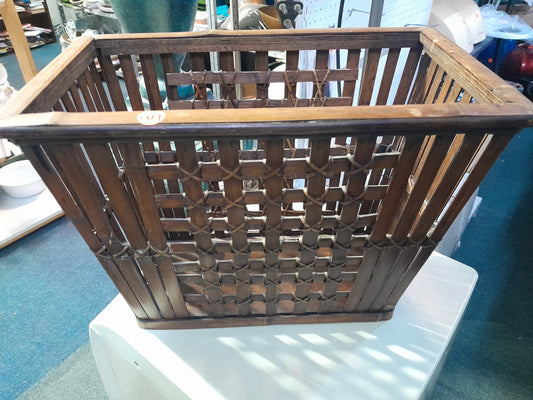 Dark brown bamboo magazine rack with intricate woven design, perfect for organizing magazines. Available at Die Skatkis secondhand store.