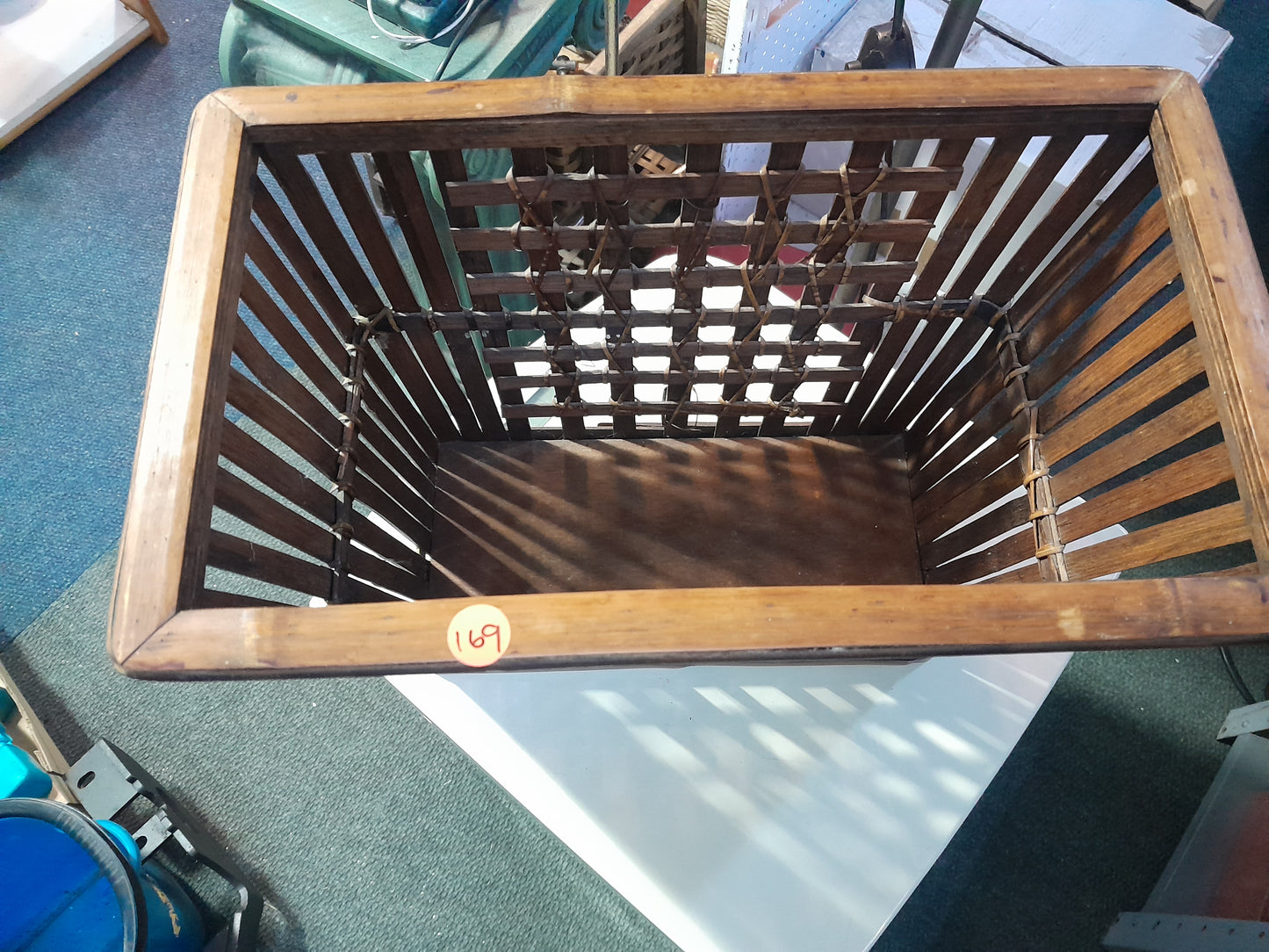 "Secondhand dark brown bamboo magazine rack, featuring vertical slats and intricate weaving. Perfect for storing magazines. Available at Die Skatkis.