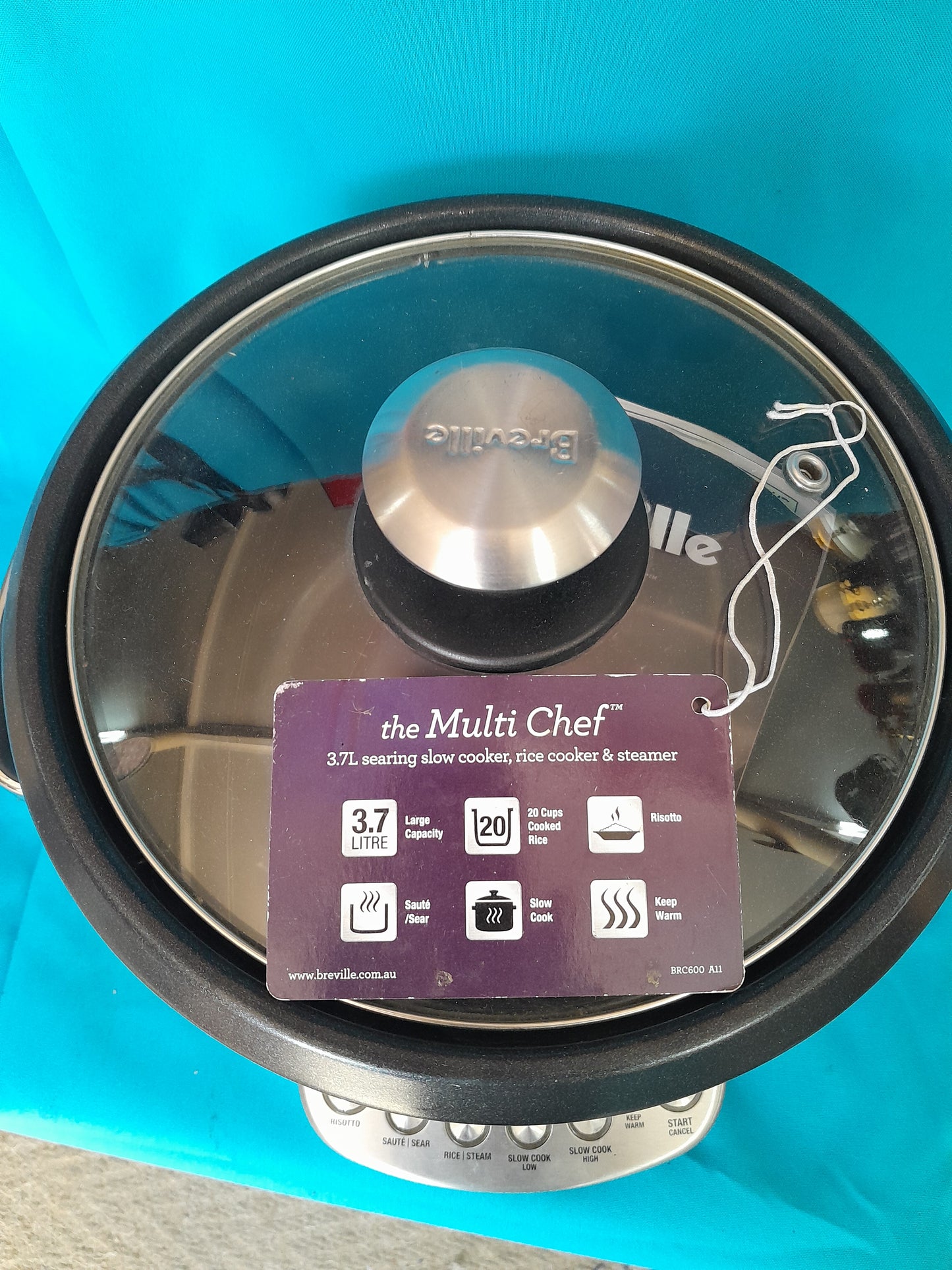 Black and silver Breville Risotto and Rice Cooker with a tag, featuring a 3.7L capacity for slow cooking, rice cooking, and steaming.