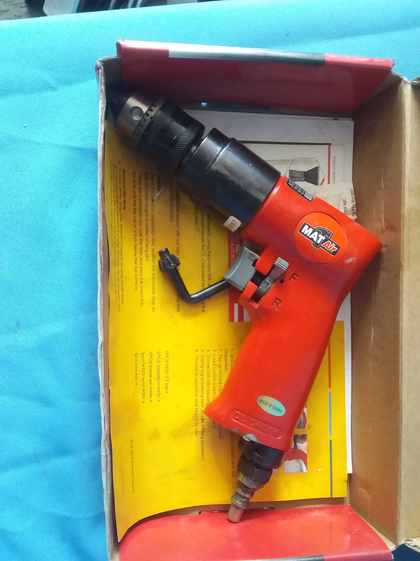 MatAir Pneumatic air drill with black chuck and quick reverse lever, placed on instruction sheet. Available at Die Skatkis.