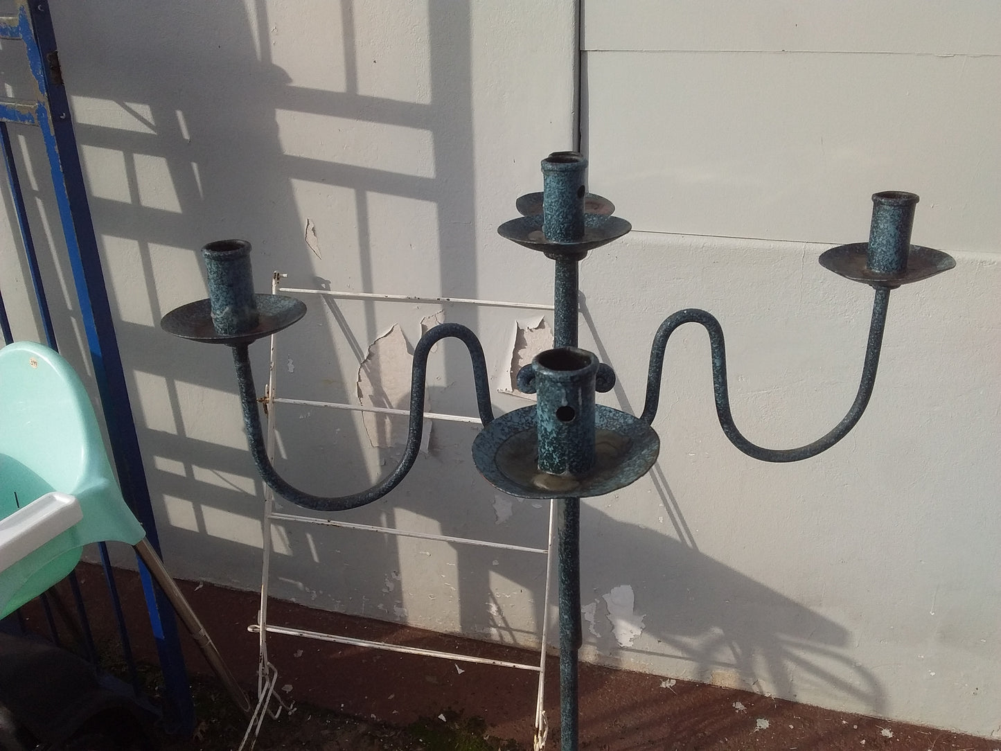 Vintage metal candelabrum with a weathered blue-green patina, featuring four curved arms, available at Die Skatkis.