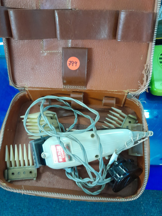 Vintage Wahl clippers displayed in a leather case, showing the model MC with working condition.