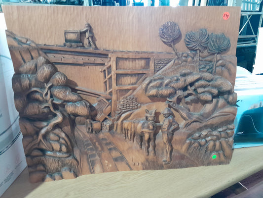 Stunning wooden carving of a pastoral scene featuring trees, animals, and human figures in detail.