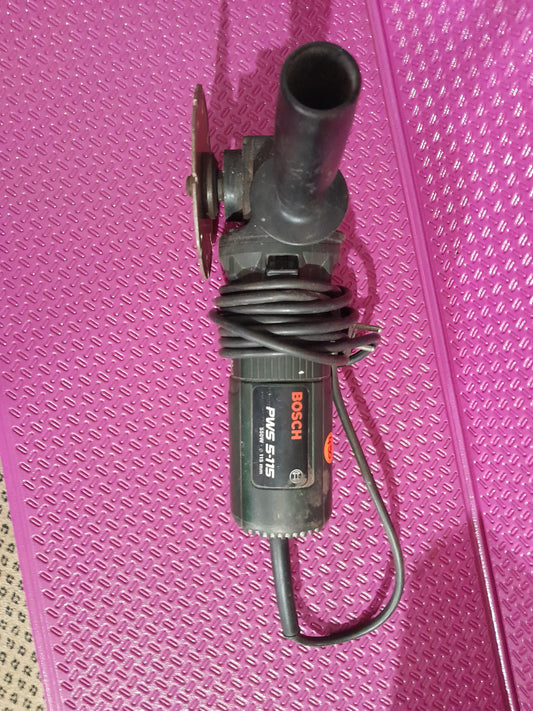 Bosch PWS 5-115 angle grinder on a pink surface, showcasing its compact design for DIY projects.