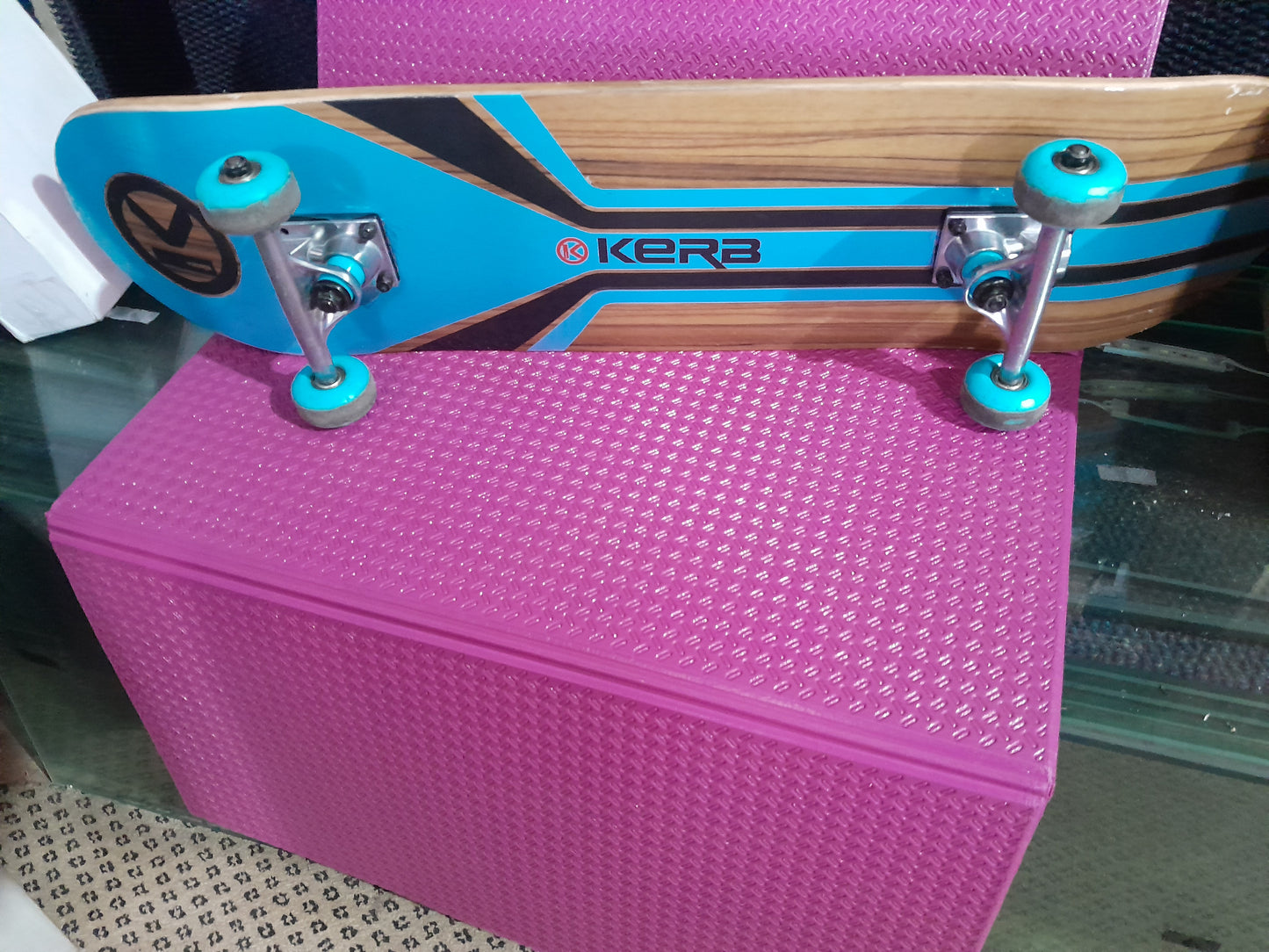 Kerb skateboard resting on a pink surface, highlighting its design and functionality for sports.