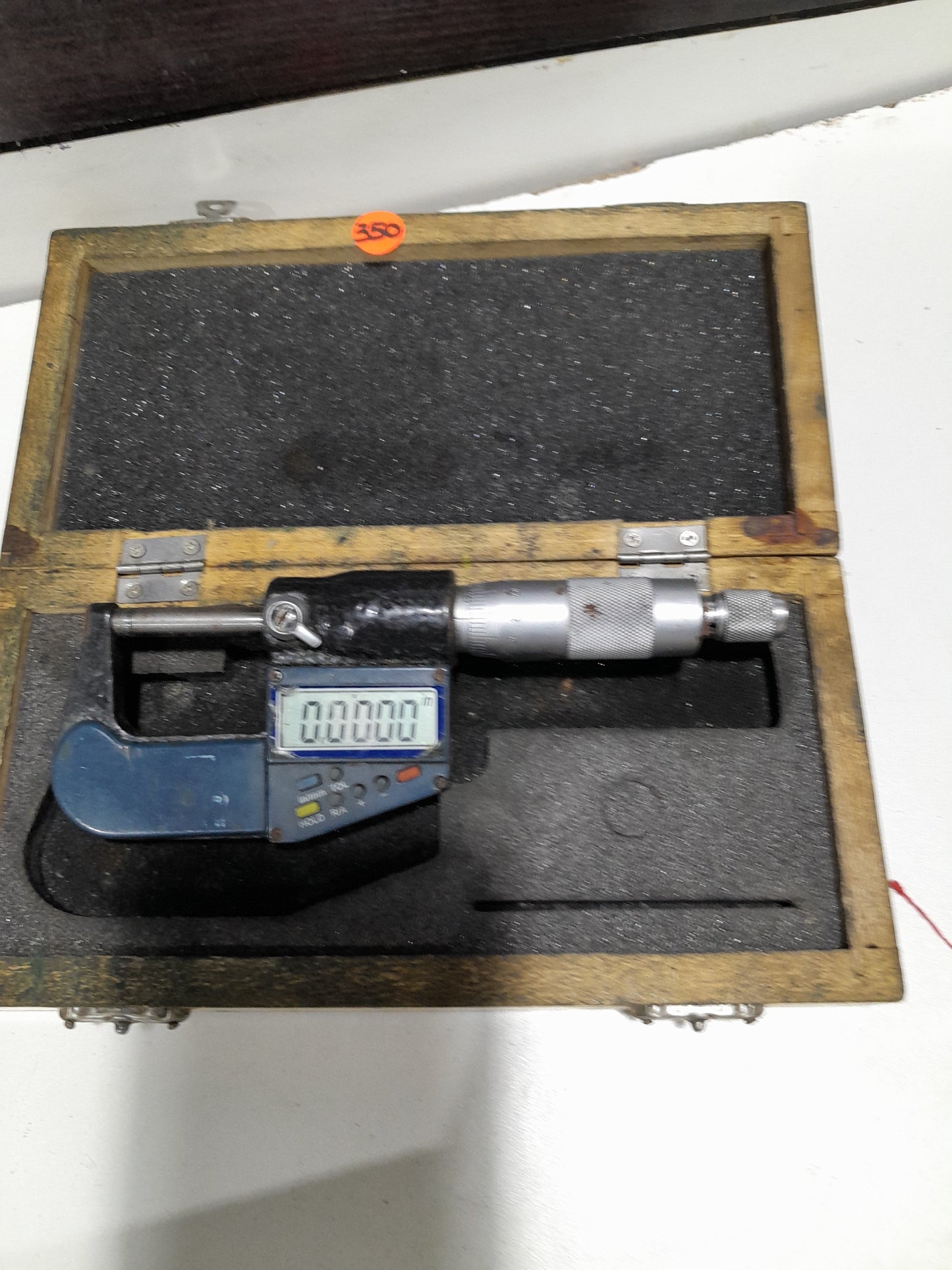Electronic digital micrometer in its protective case, designed for accurate measurement of small distances.