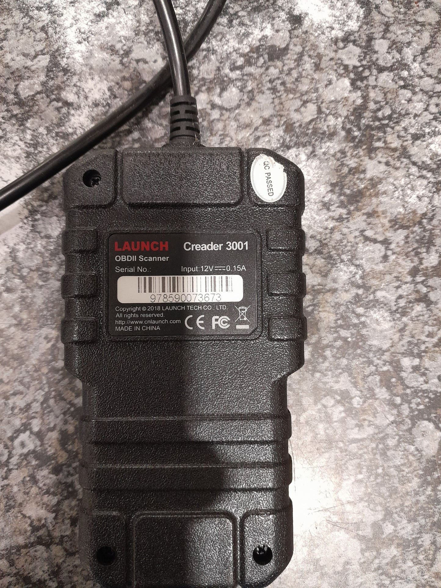 Creader 3001 OBD2 scanner displayed on a textured surface, great for vehicle diagnostics.