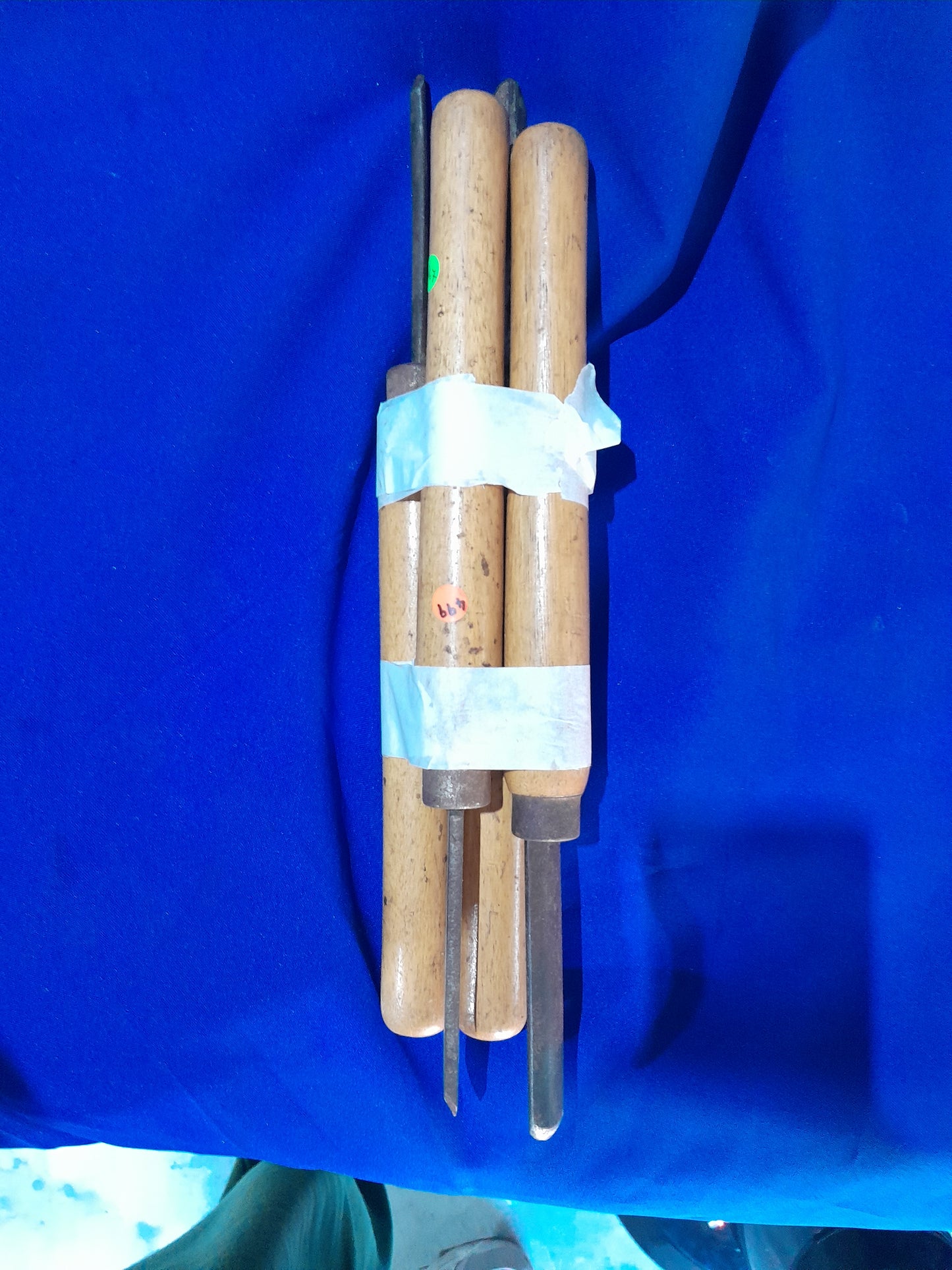 Four woodturning chisels with wooden handles, bundled with white tape, ideal for precise woodworking and carving tasks.