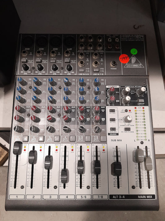 Behringer Xenyx 1204 USB mixer with 12 channels and audio mixing capabilities.