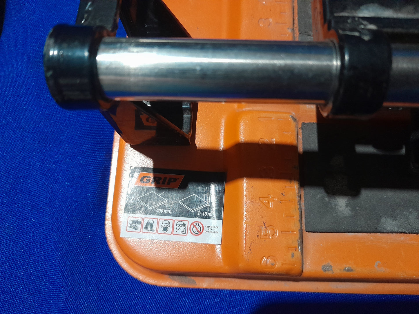 Close-up of a grip manual tile cutter, showcasing its features for precise tile cutting.