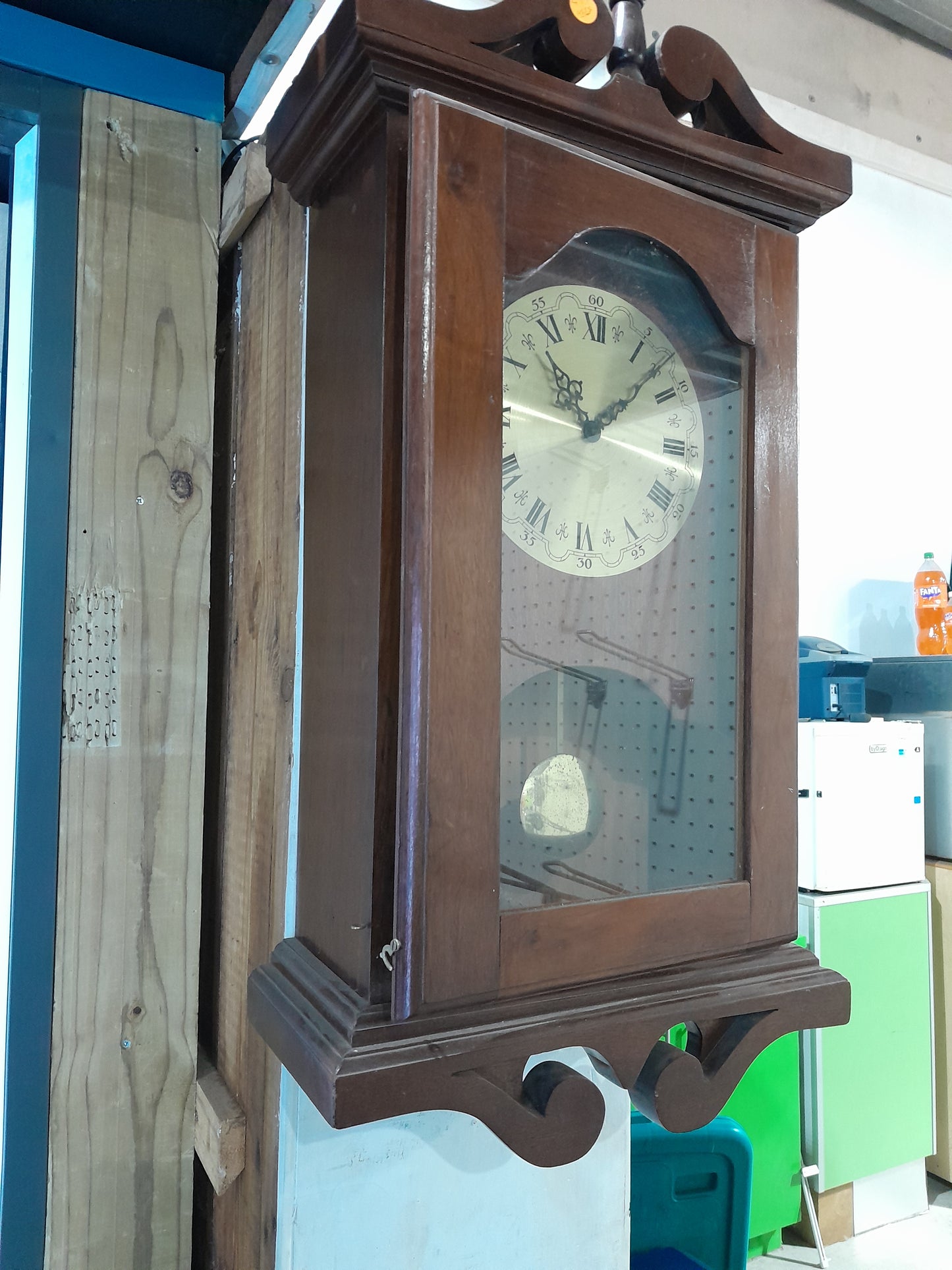 Classic antique clock with glass front and wooden frame, a charming addition to any room.