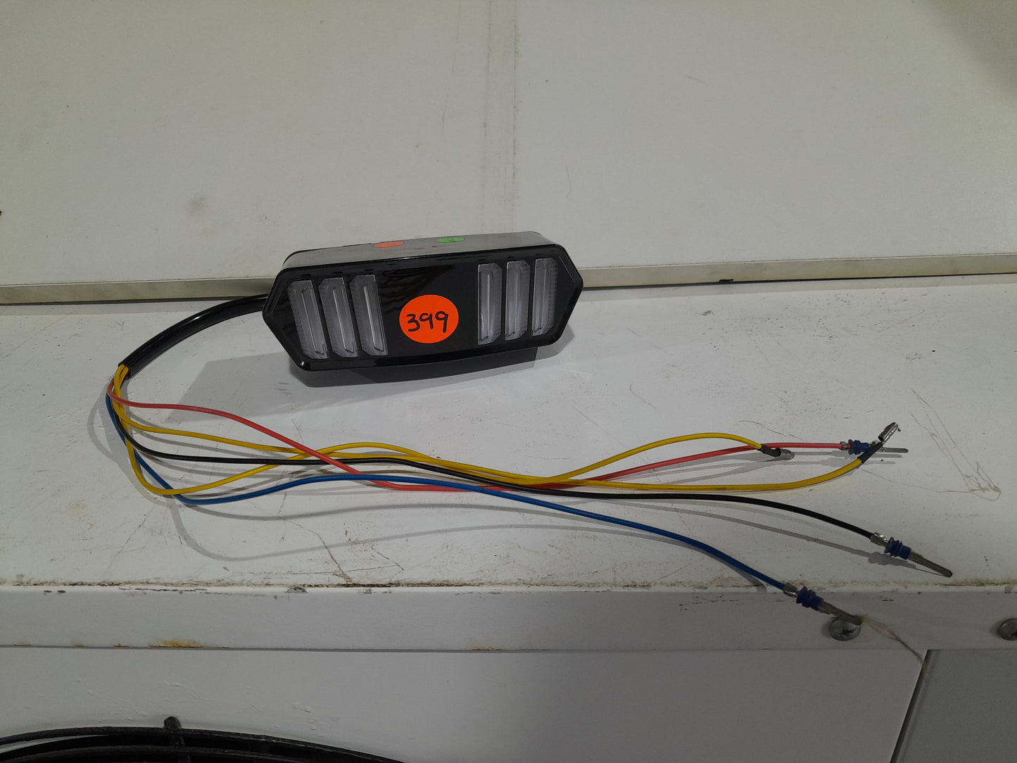 Sleek motorcycle LED tail light showcasing brake and turn signal functionality in one unit.