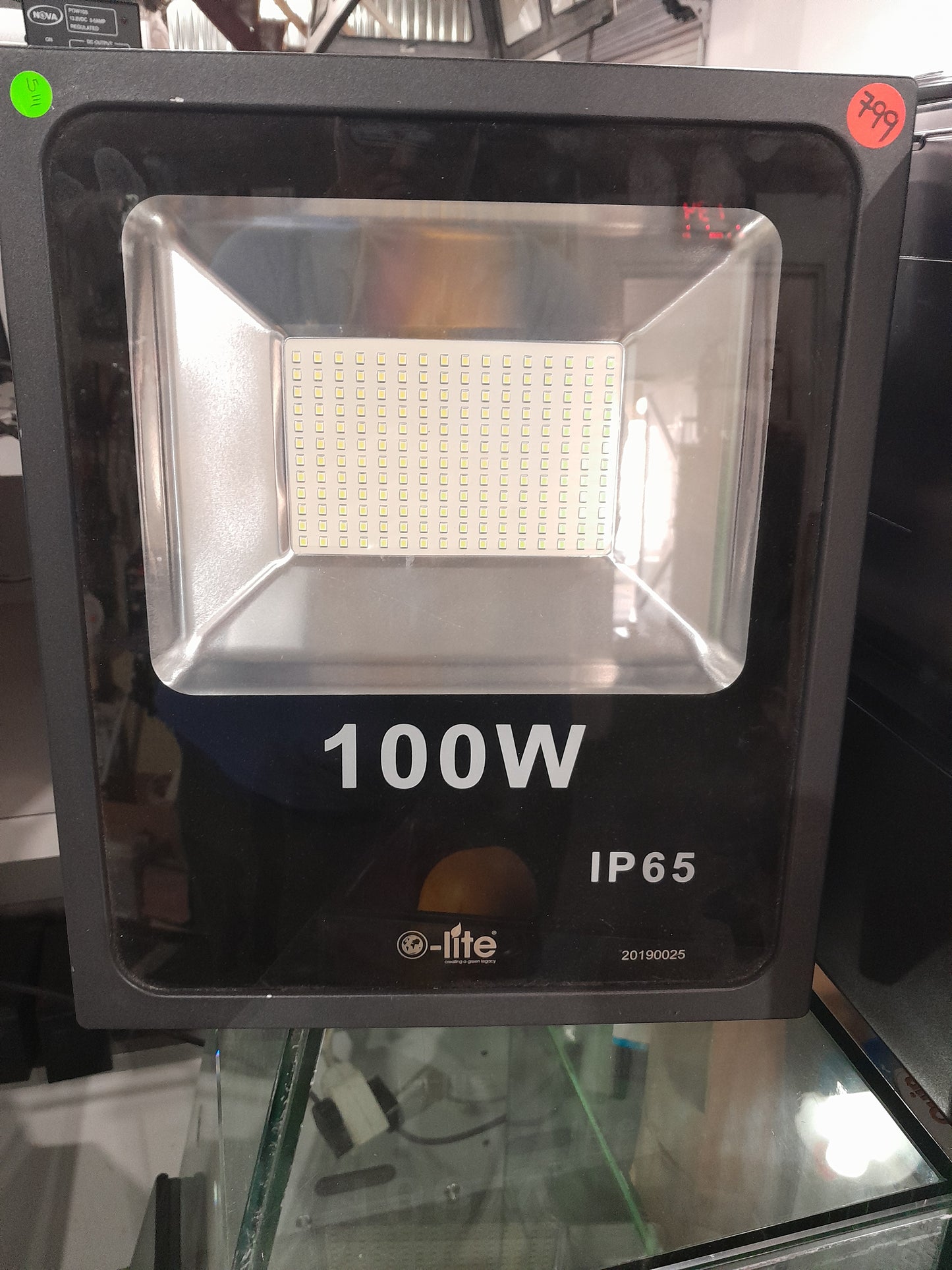 e-lite 100W LED floodlight displayed in secondhand store, suitable for various outdoor lighting needs.