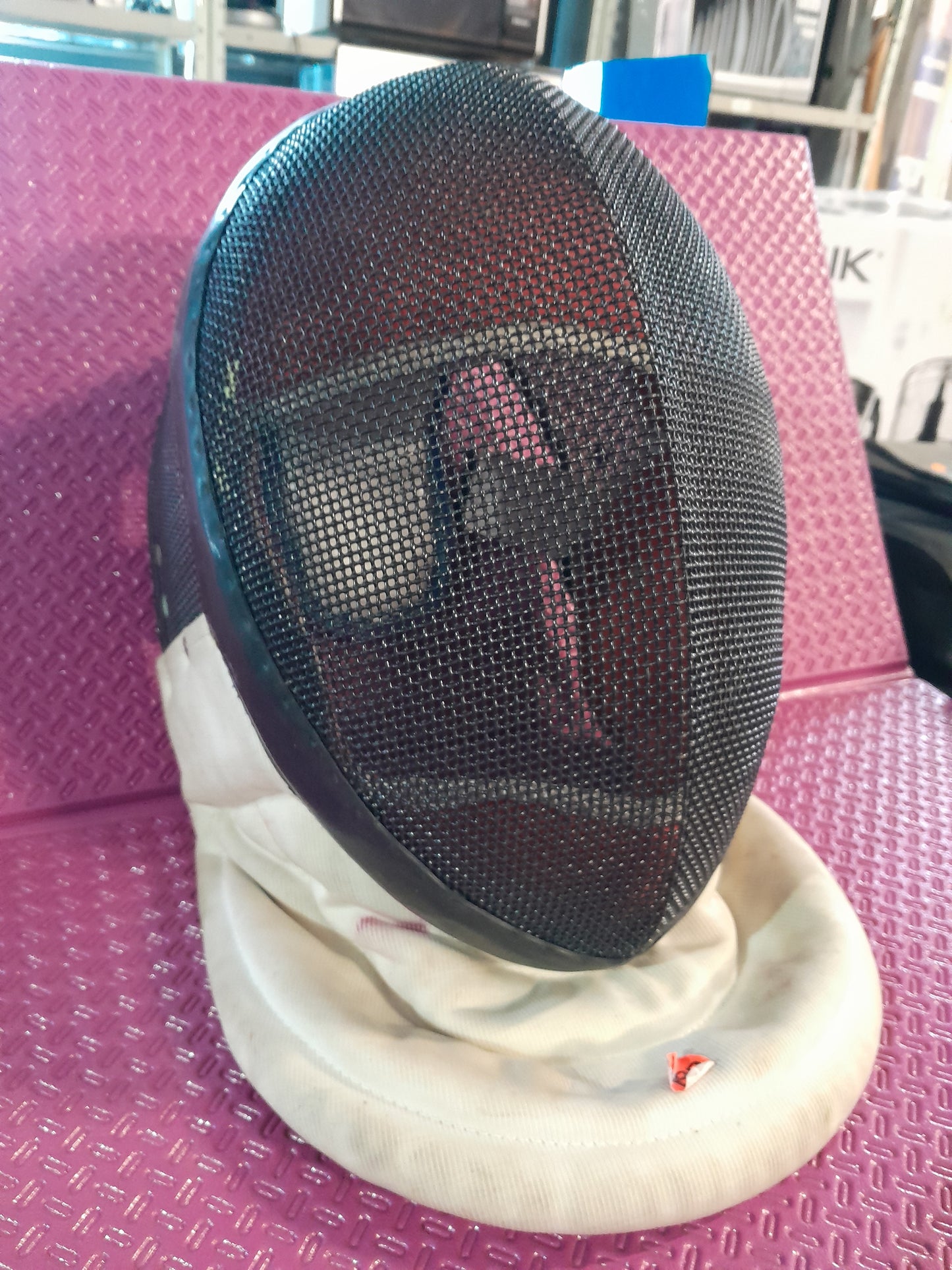 Durable fencing mask featuring a mesh structure for impact resistance and neck protection.