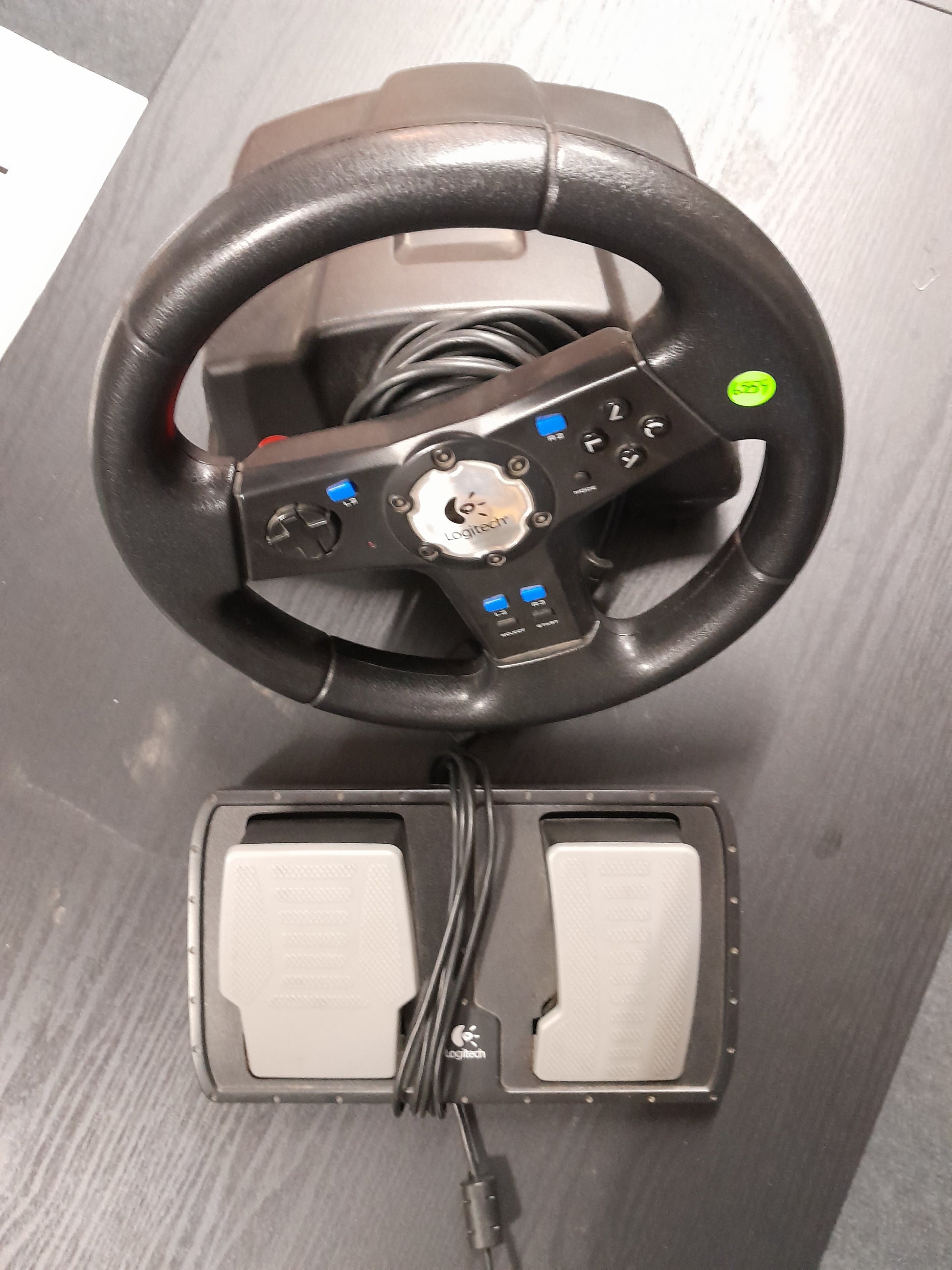 Logitech gaming steering wheel and pedals for PS2, perfect condition. Enhance your gaming setup with this pre-owned set from Die Skatkis.