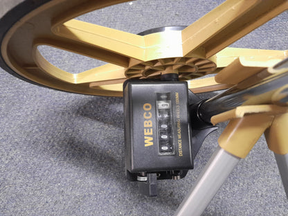Close-up of Webco Distance Measuring Wheel counter, displaying '0009' with yellow wheel, black rubber edge, and handle, available at Die Skatkis.