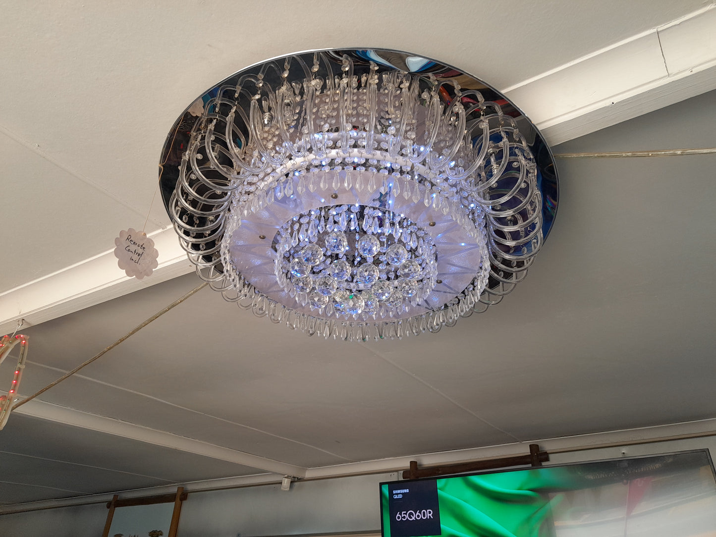 Remote-controlled crystal chandelier with a metallic base, clear and blue illumination. Adds sophistication to your space. Available at Die Skatkis.