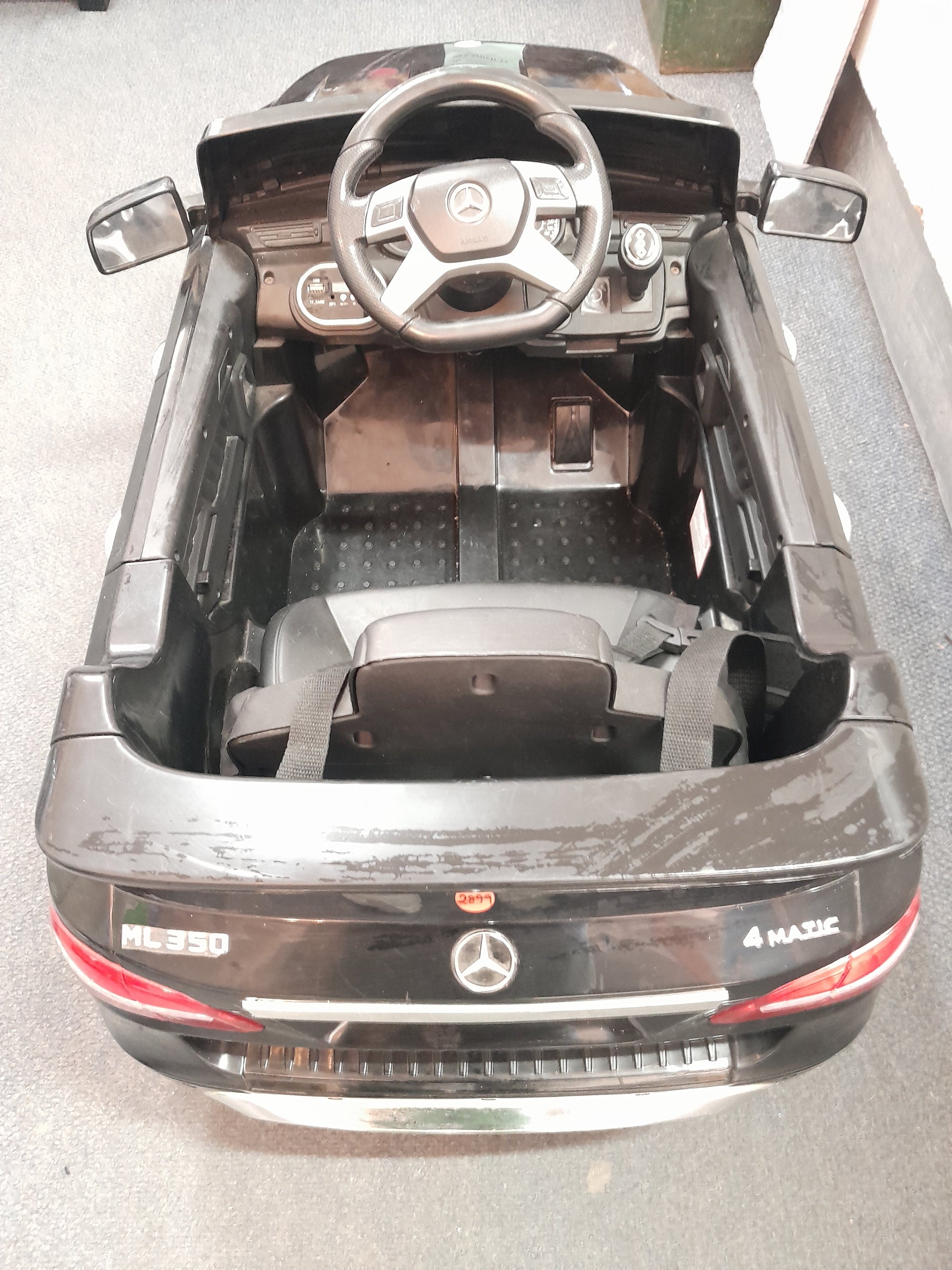 Black Mercedes Benz kiddies car, ML350 model, featuring detailed interior with steering wheel and dashboard, available at Die Skatkis.