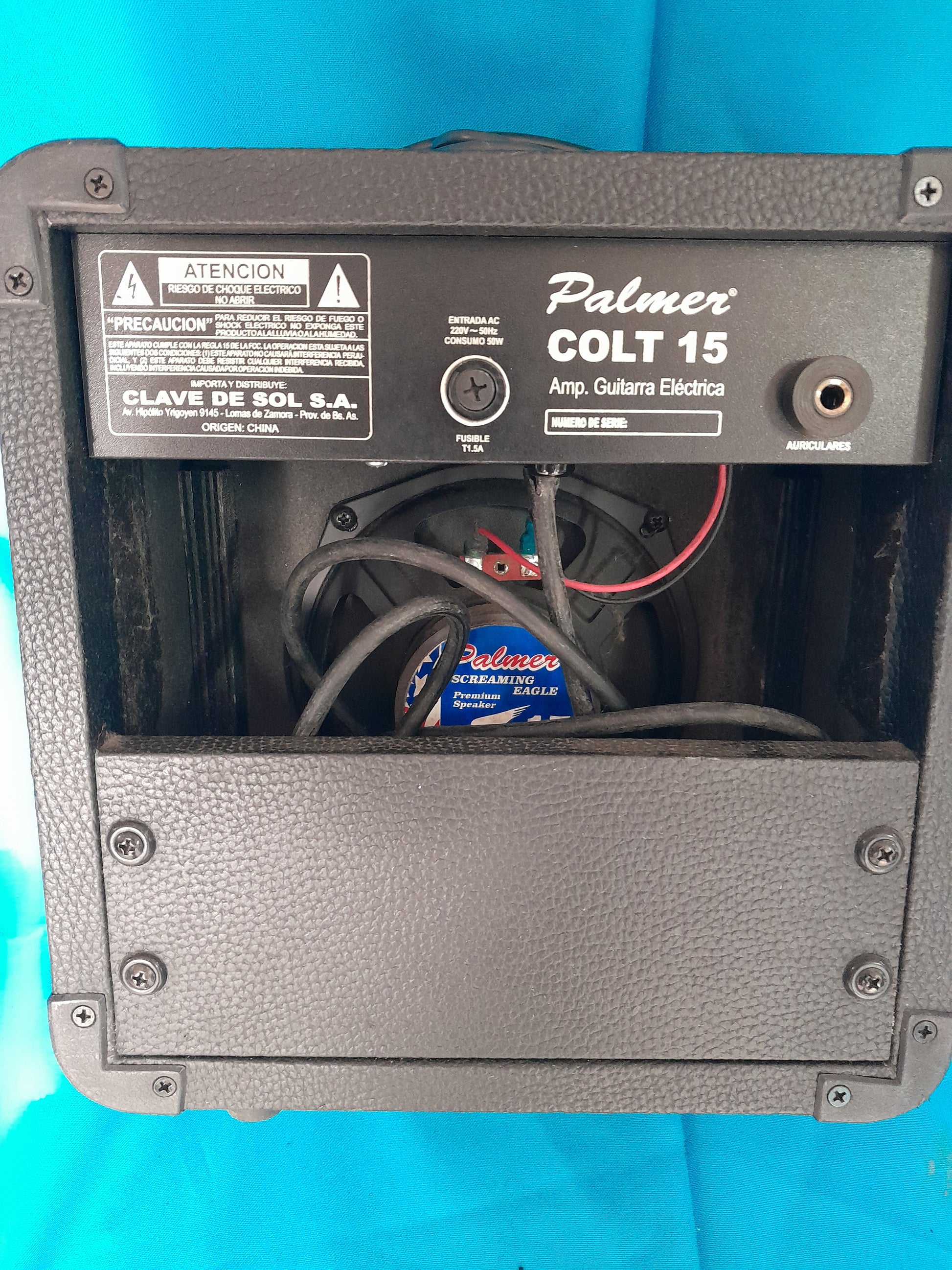 Back view of Palmer Colt 15 Guitar Amplifier, partially open to show internal components like wires and a speaker.