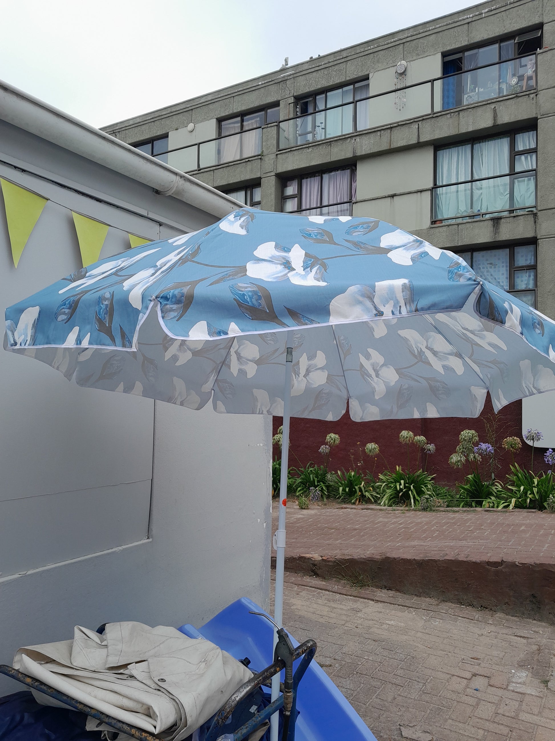 Secondhand Design House Maldives umbrella, 200 cm, with blue and white floral design. Perfect for hot summer days. Available at Die Skatkis.