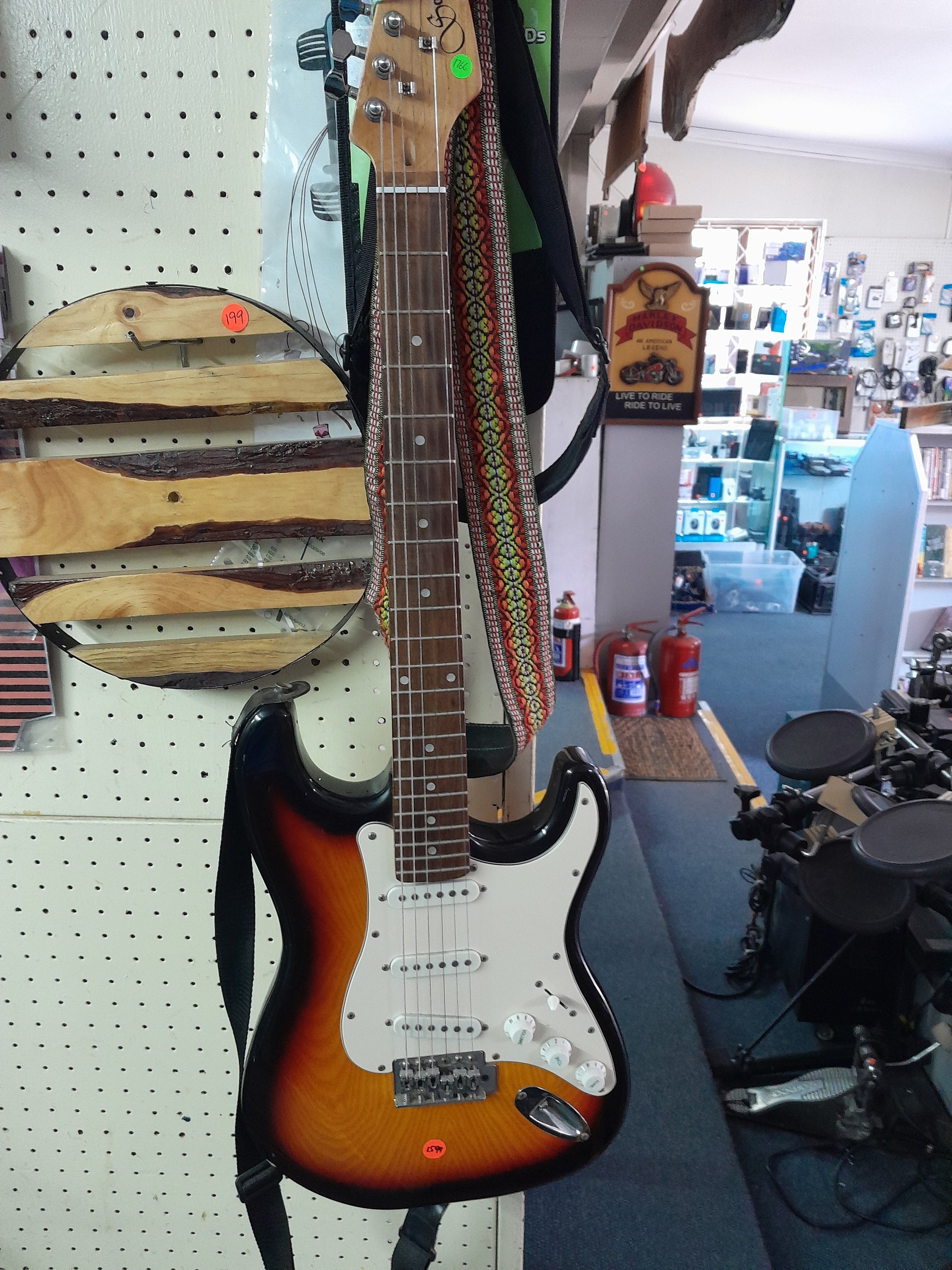Santa Fe electric guitar with a 3-tone finish, perfect for beginners, displayed in a secondhand store.