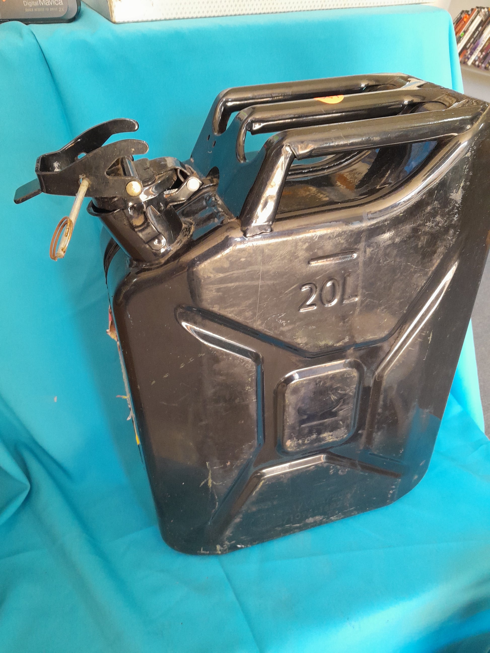 "Black 20L Jerry can with handle and secure spout, marked '20L', ideal for storing fuel, available at Die Skatkis.