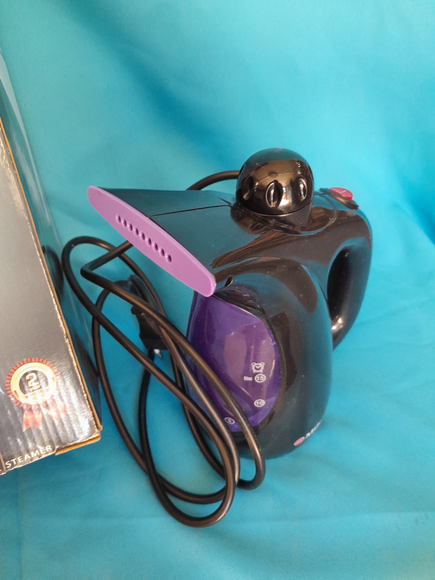 Milex Hand-Held SteamerPro with purple nozzle and black body, ideal for de-wrinkling garments and curtains, available at Die Skatkis.
