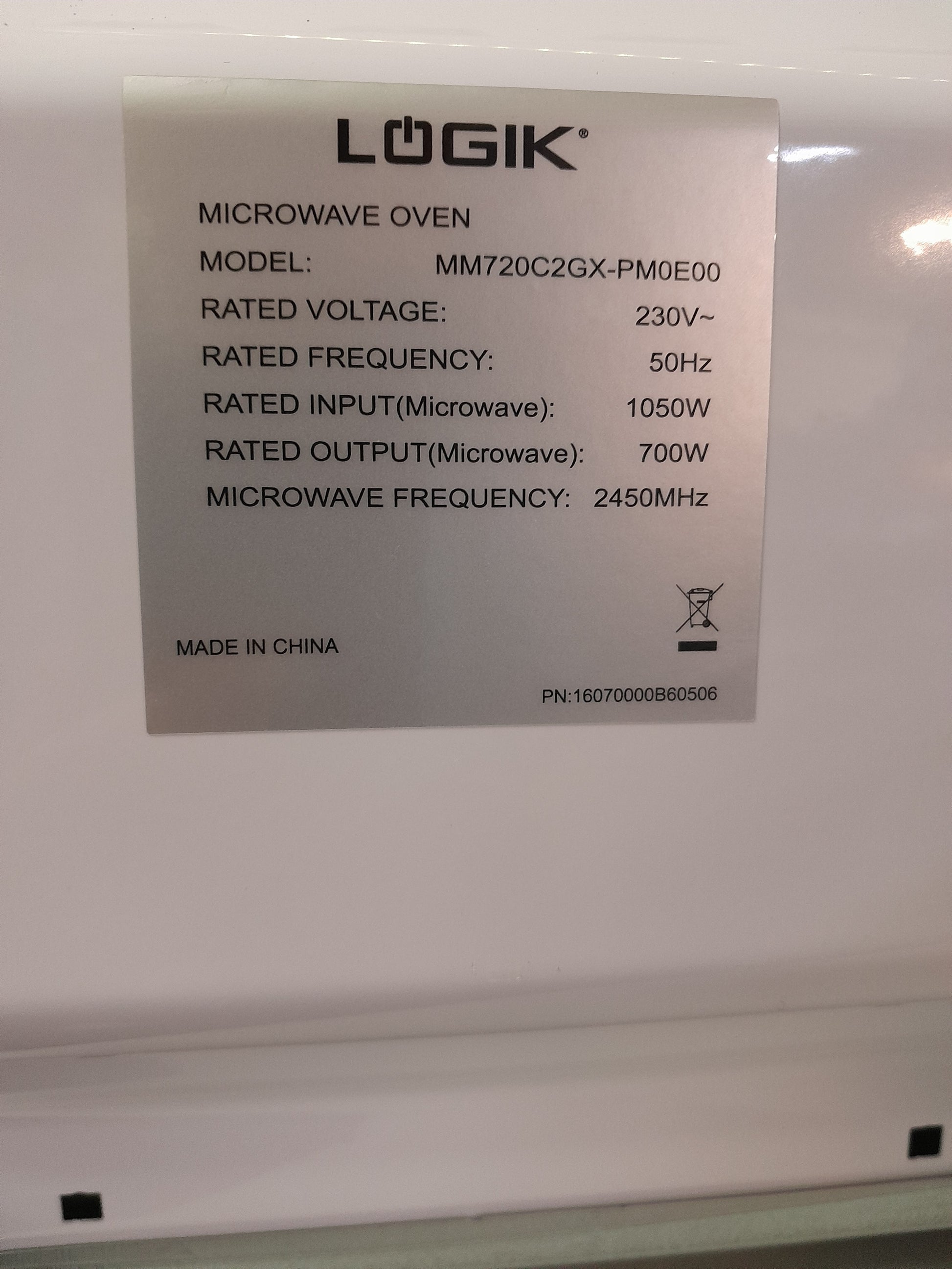 Technical specifications label of a Logik 20 Litre microwave, model MM720C2GX-PM0E00, showing voltage, frequency, and power details, available at Die Skatkis secondhand store.