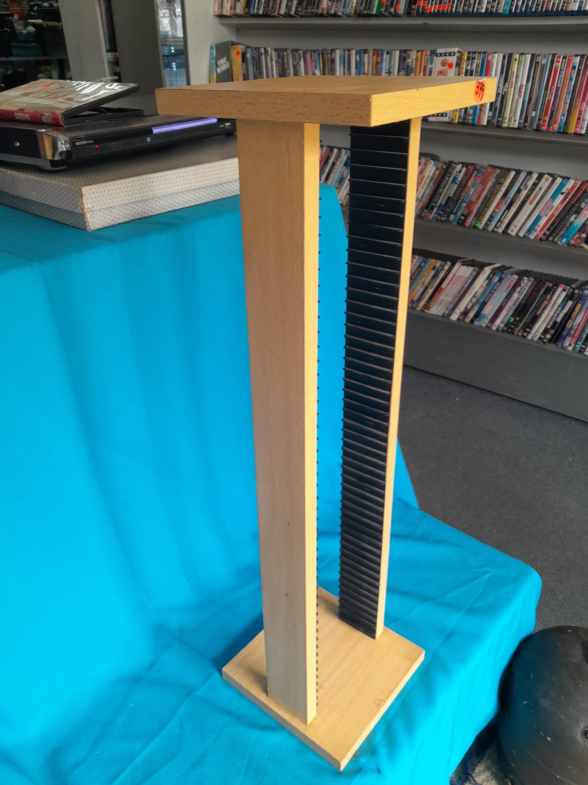 Wooden CD storage rack with a sturdy design and a metal rod for easy organization—perfect for secondhand goods at Die Skatkis.