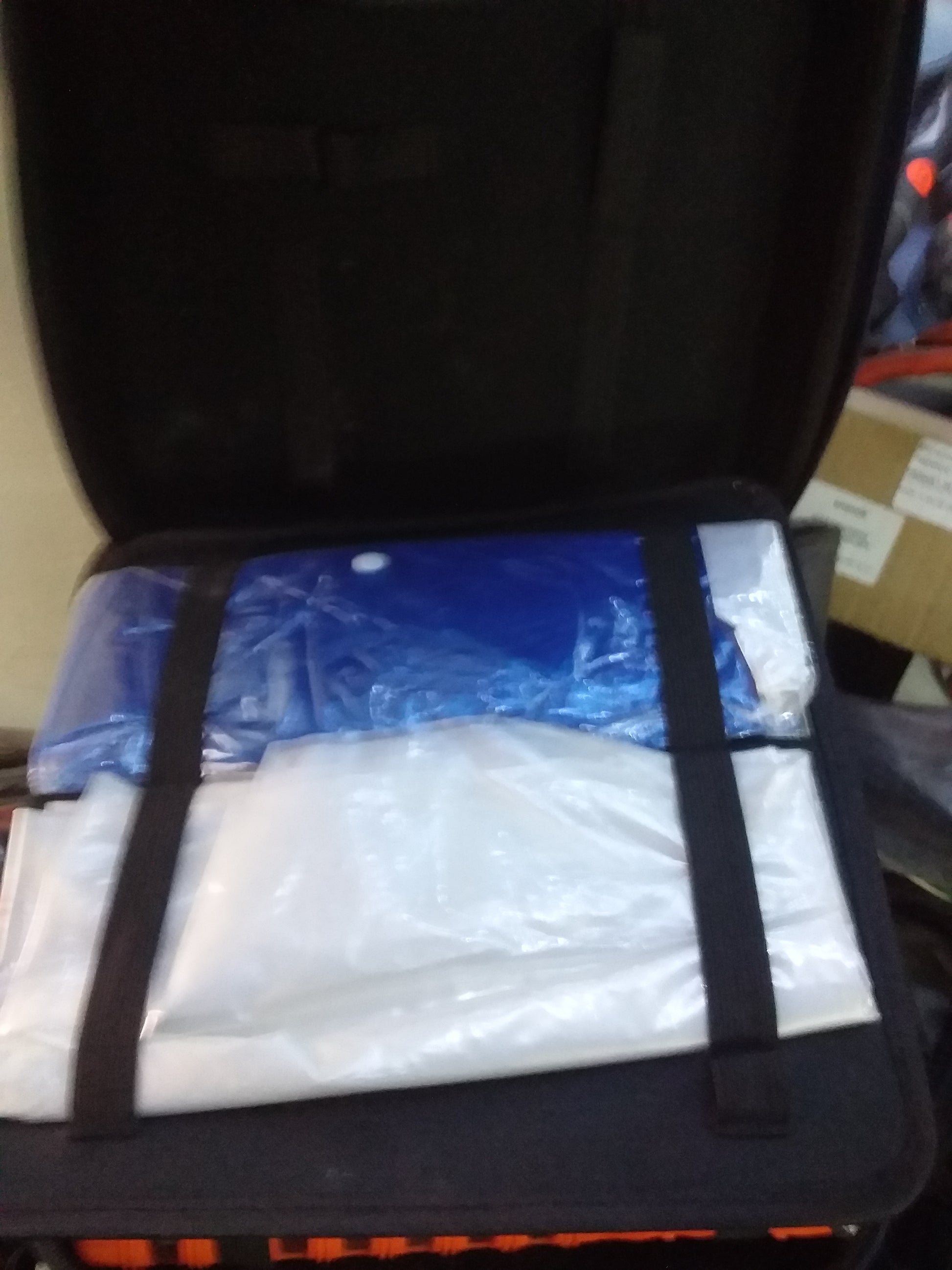 Auto Pedigree emergency car kit contents including blue and white folded plastic sheets in a black case. Available at Die Skatkis.