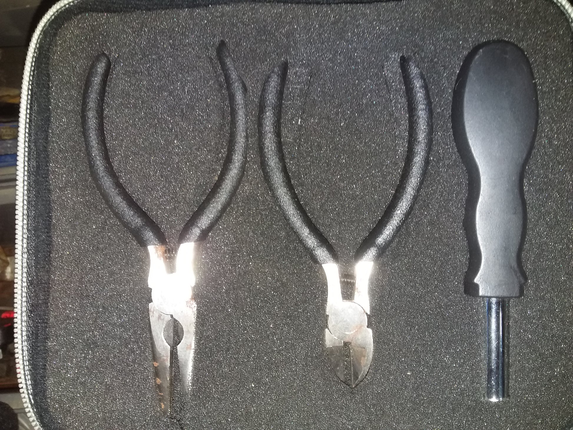 "Mini tool set in a foam-lined case, featuring needle-nose pliers, diagonal cutting pliers, and a screwdriver. Available at Die Skatkis.