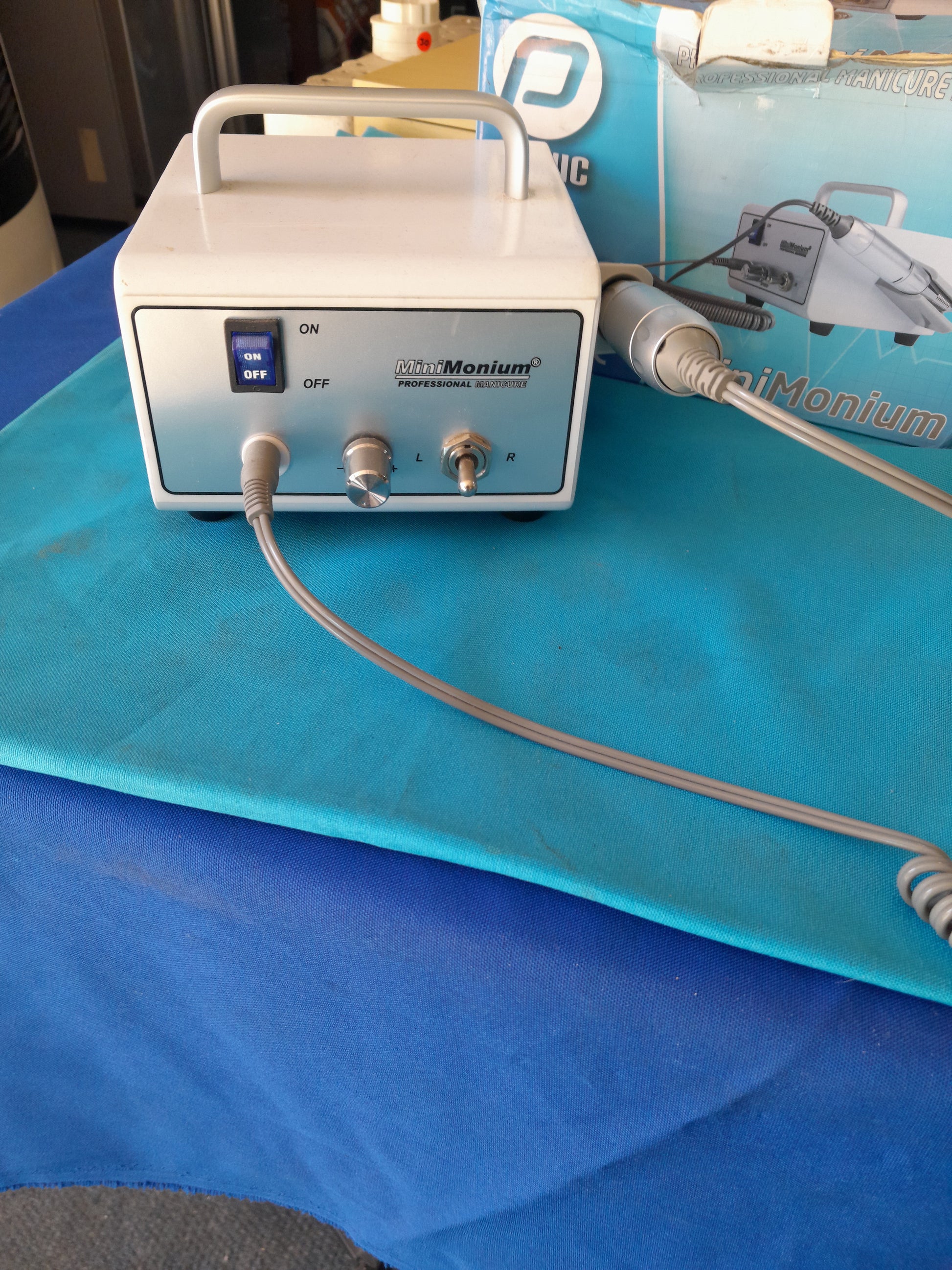MiniMonium manicure drill next to its original box, perfect for nail care enthusiasts.