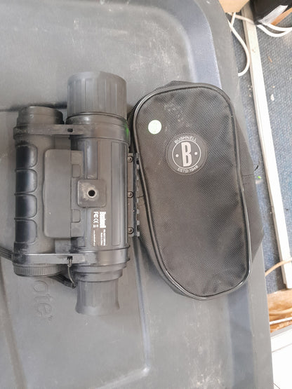 "Bushnell Equinox Z night vision device and carrying case with Bushnell logo, placed on a black surface. Available at Die Skatkis.