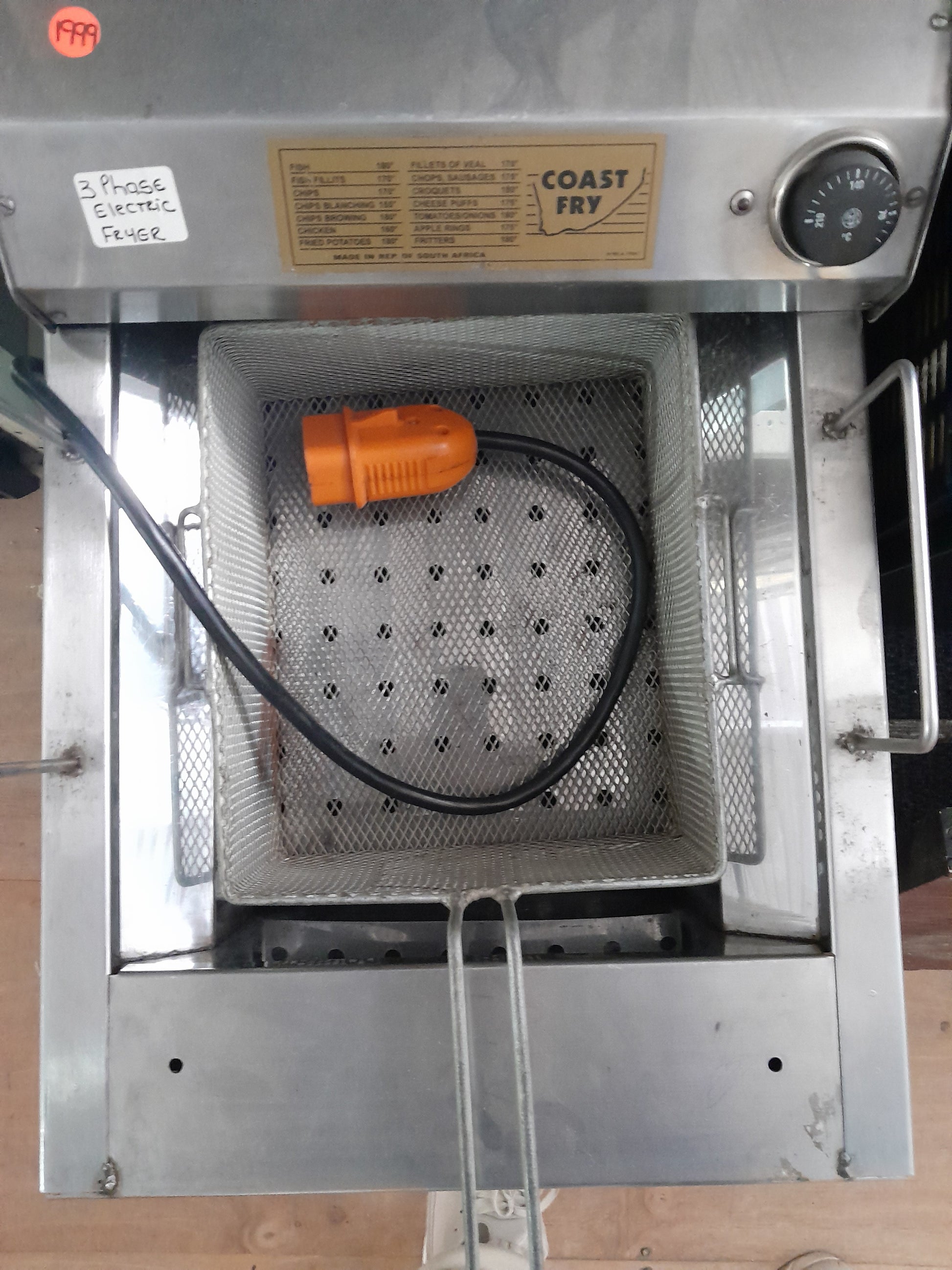 Top view of a 3 phase electric fryer with stainless steel basket and heating element.