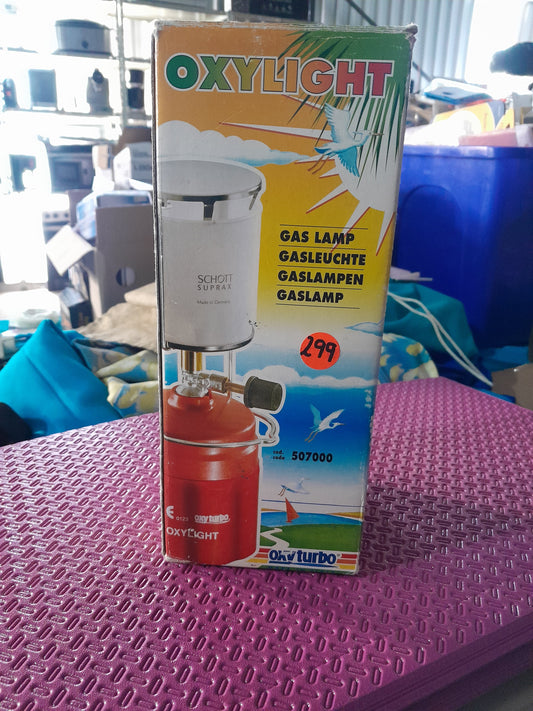 Oxylight gas lamp in use, providing bright light for camping and outdoor activities.