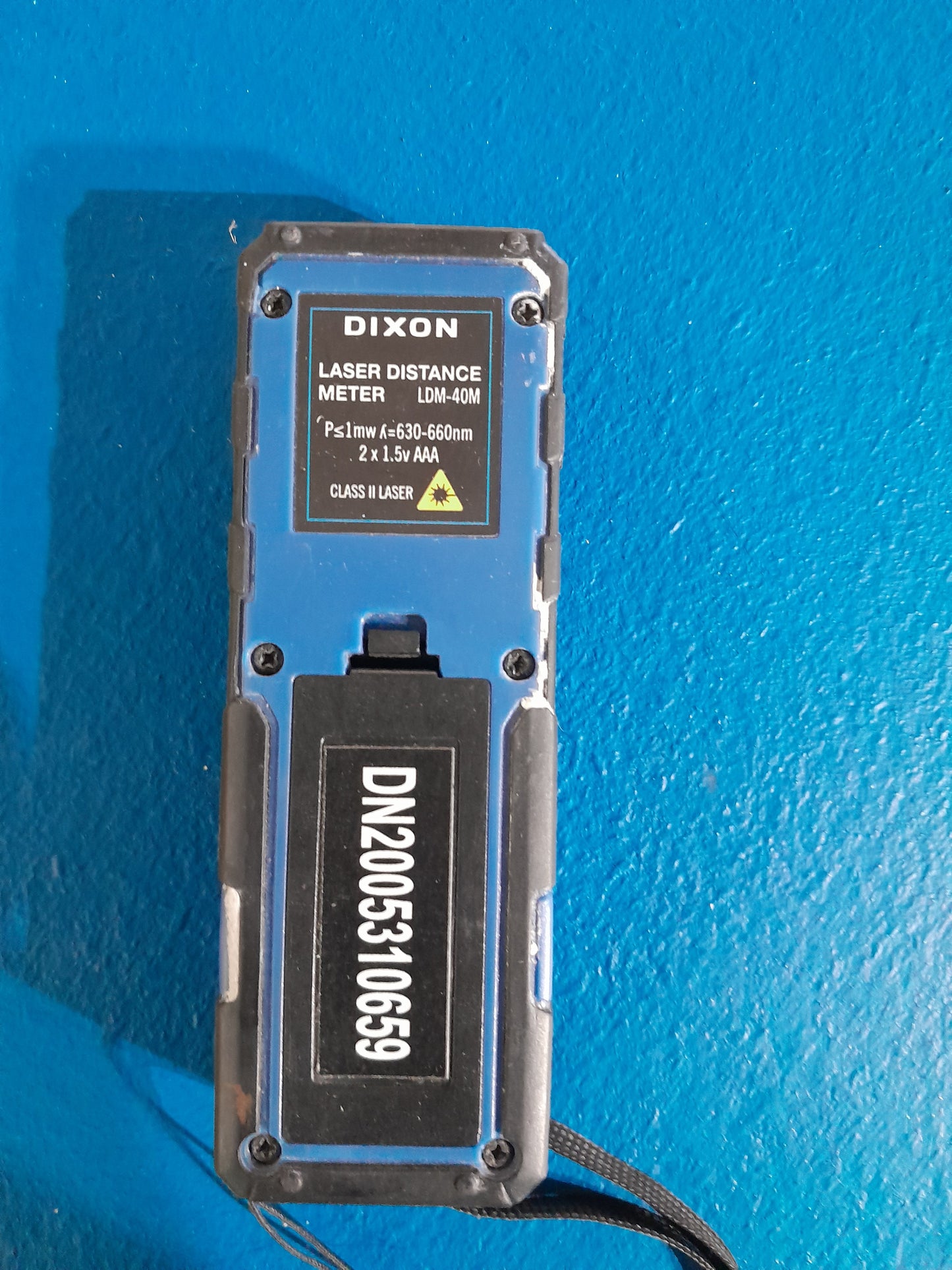 Dixon LDM-40M laser distance meter displayed against a blue background, emphasizing its compact design.