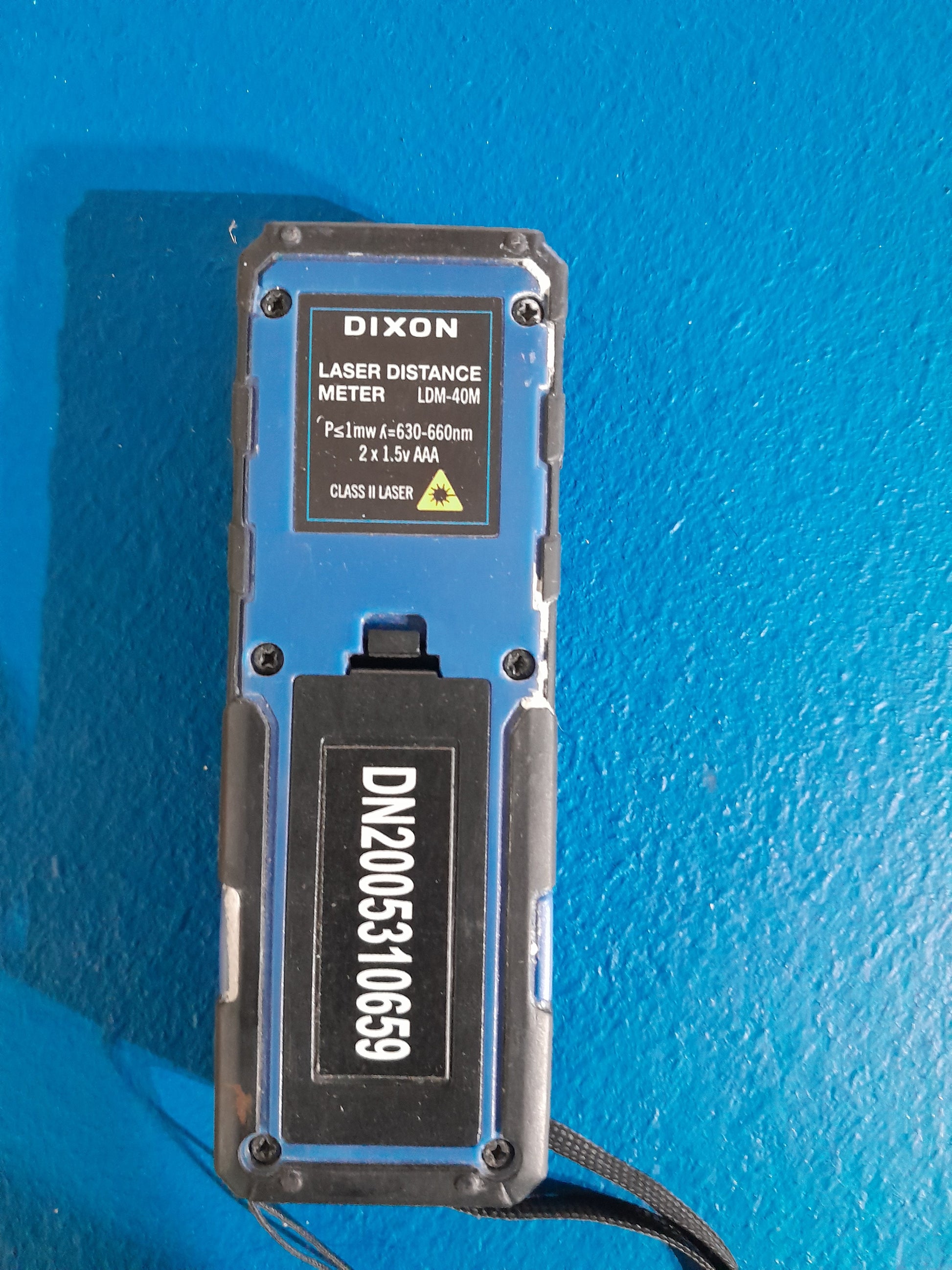 Dixon LDM-40M laser distance meter displayed against a blue background, emphasizing its compact design.