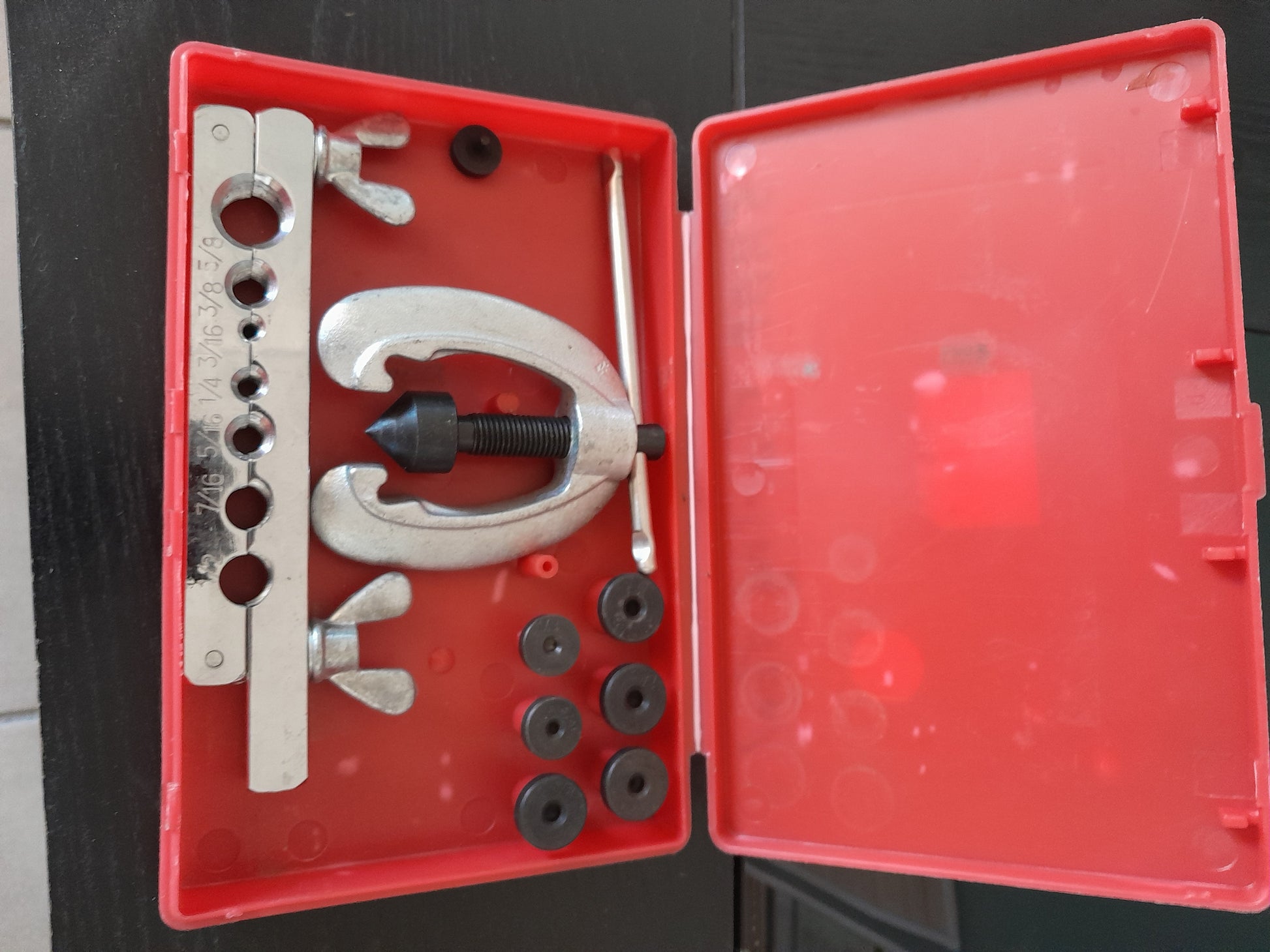 Open case of a pipe flaring kit with various tools for creating leak-proof connections.