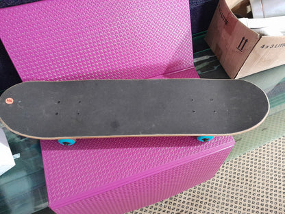 Top view of a used Kerb skateboard with a wooden deck and blue wheels, ideal for recreation.