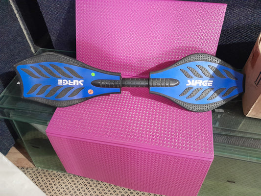 Top view of a Surge J-Board, highlighting its two-wheeled design and independent rotation feature.
