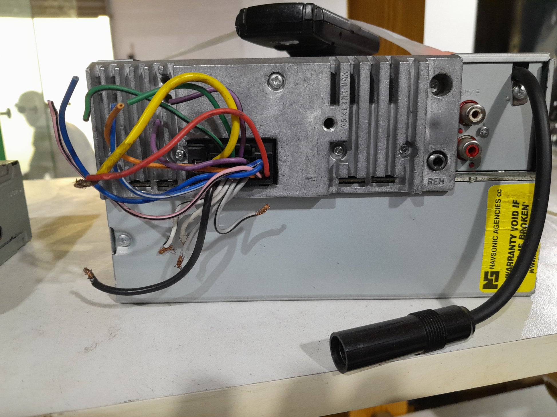 Rear view of Alpine CDE-W233R car receiver, showcasing connection ports and installation setup.