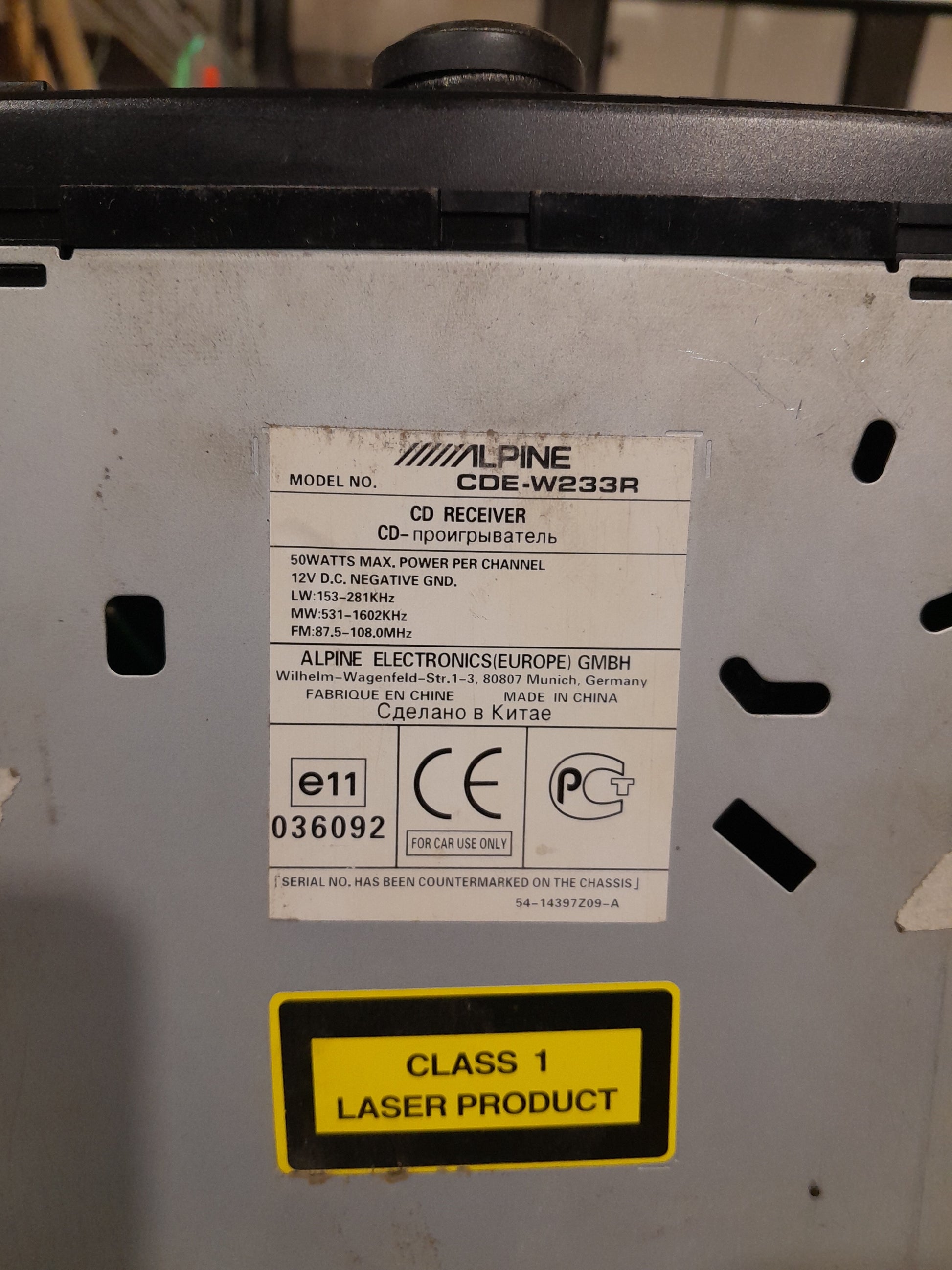 Product information label of Alpine CDE-W233R 2-DIN car receiver with power ratings.
