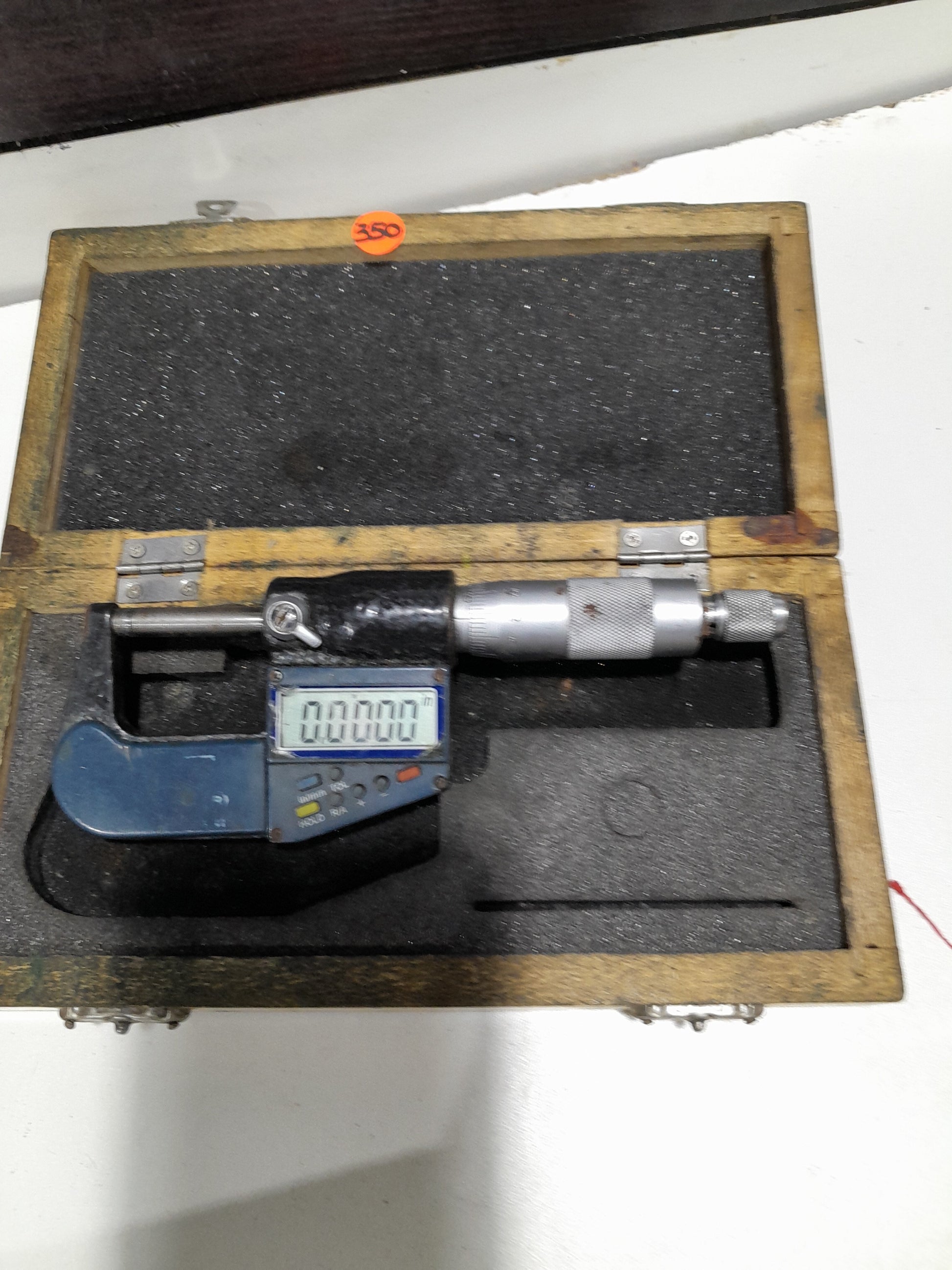 Electronic digital micrometer in its protective case, designed for accurate measurement of small distances.