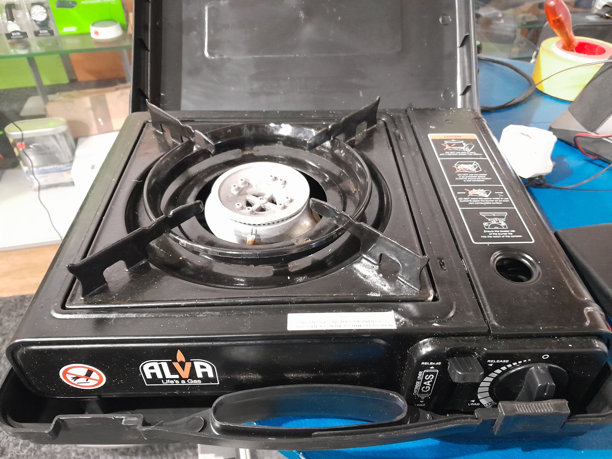Close-up of Alva canister stove with flame, ideal for outdoor cooking and emergency backup.