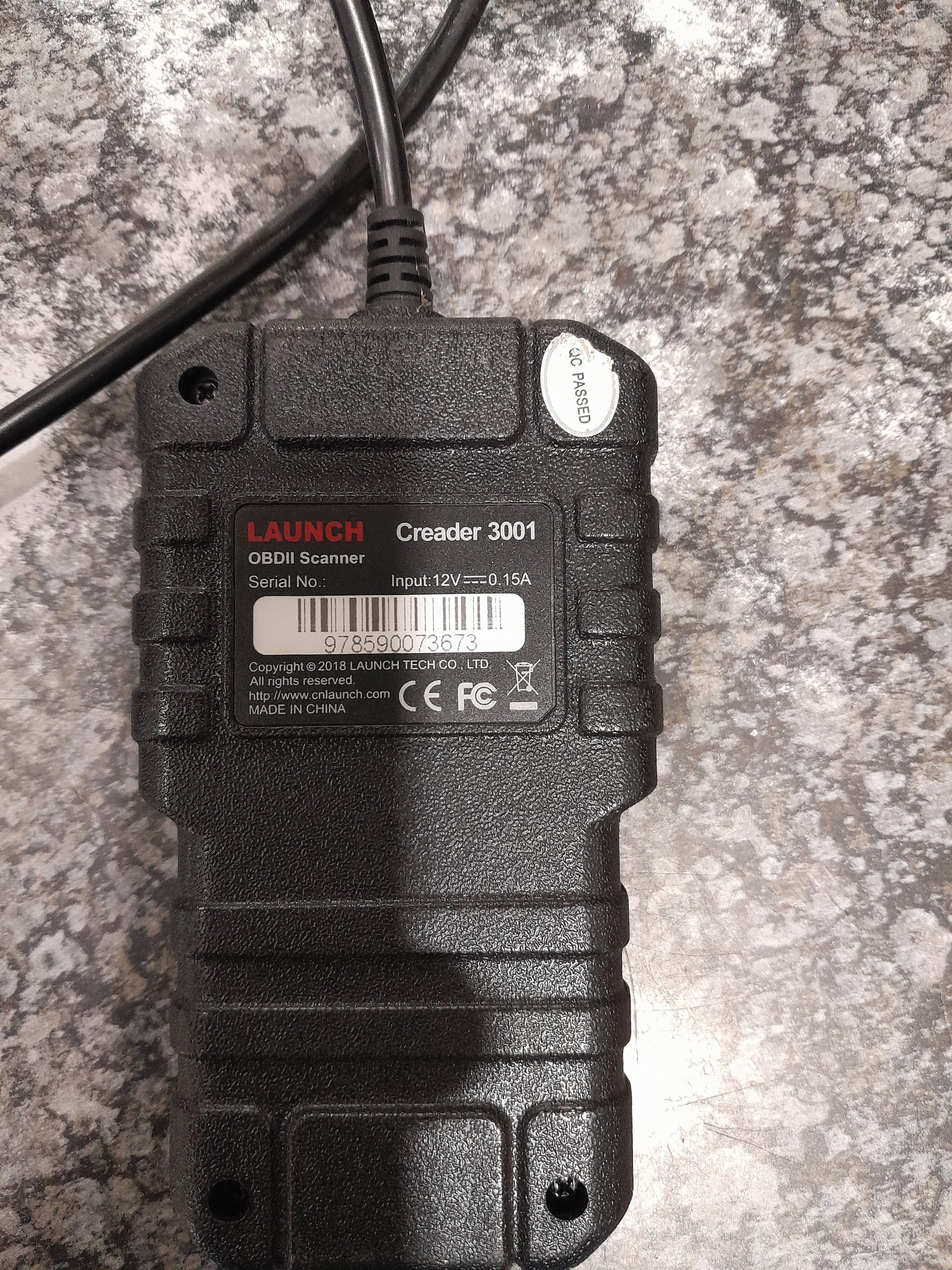 Creader 3001 OBD2 scanner displayed on a textured surface, great for vehicle diagnostics.