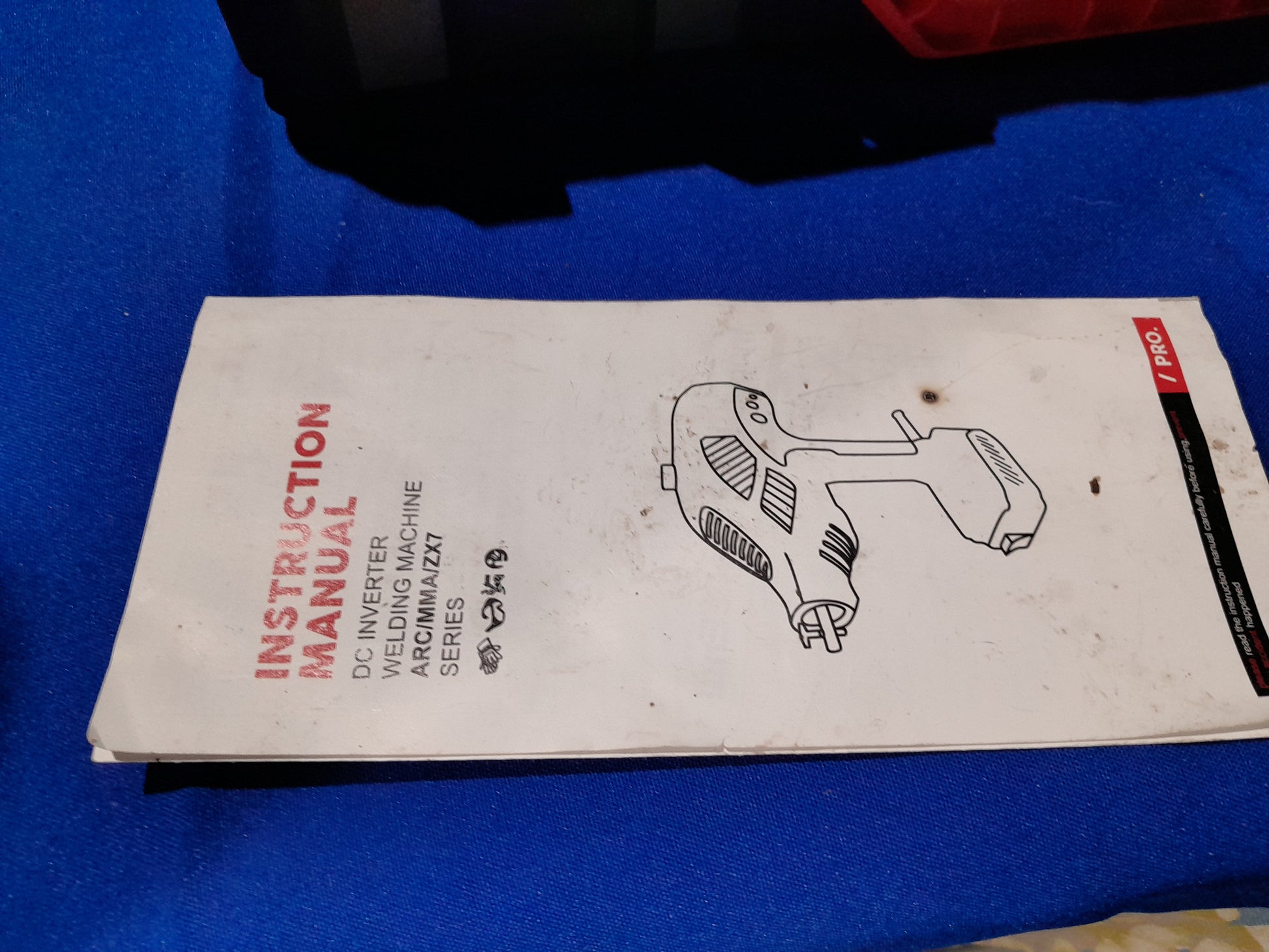 Instruction manual for ARC MMA ZX7 DC inverter welding machines, displayed on a blue surface, featuring product details.