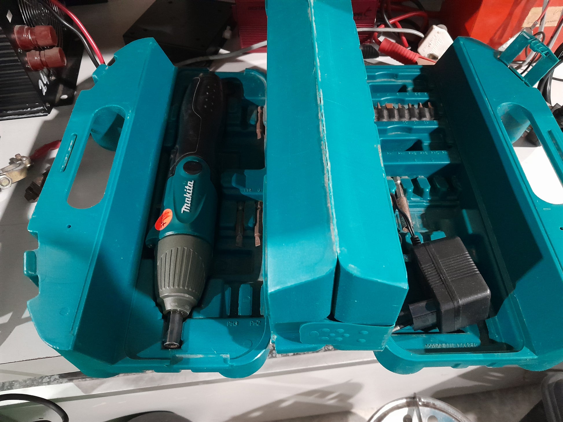 Makita cordless screwdriver with versatile design, complete with accessories, charger, and durable teal carry case.